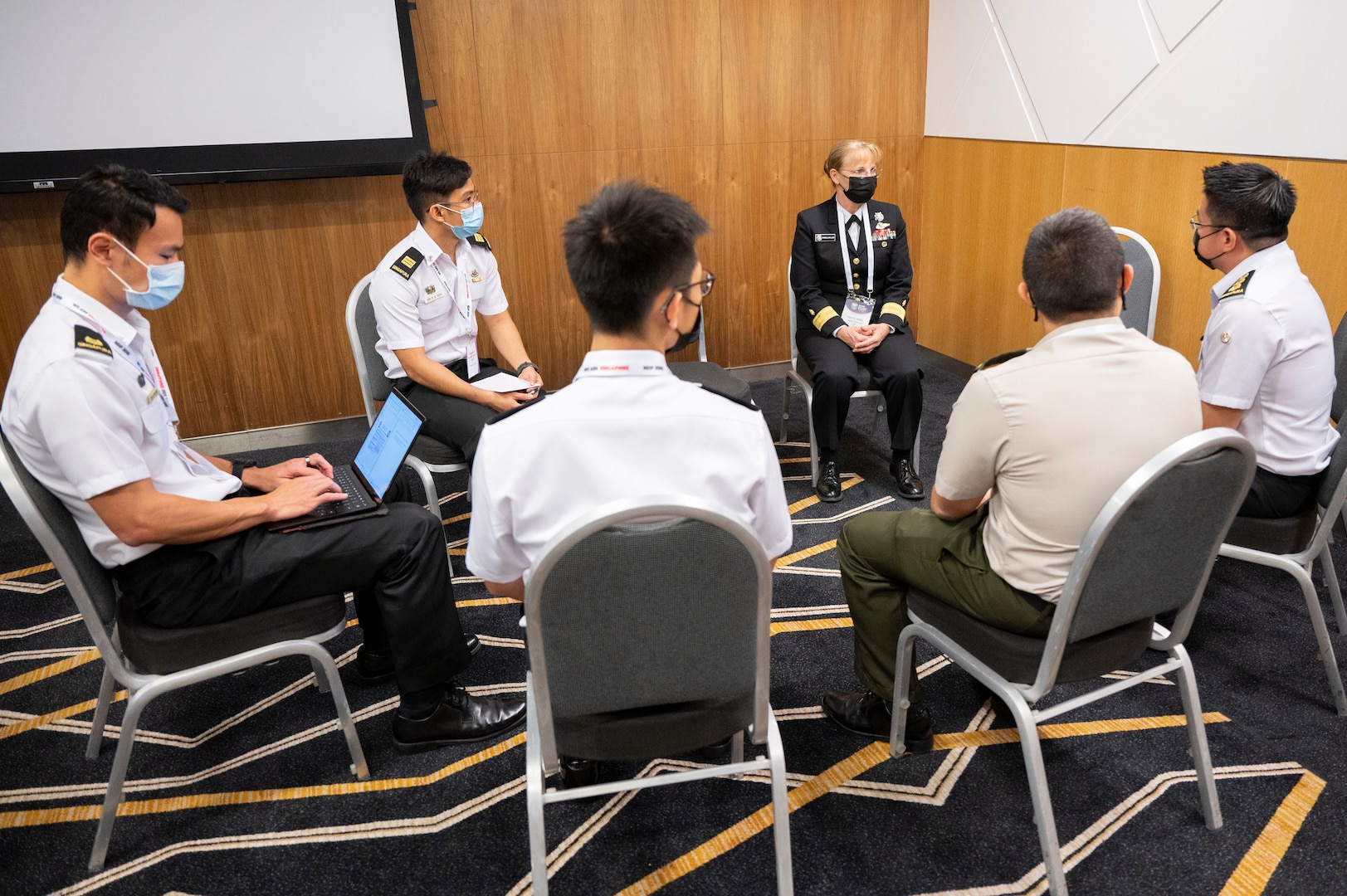 Rear Adm. Pamela Miller (rear-right), Command Surgeon for U.S. Indo-Pacific Command, speaks with delegates from Singapore during the second Military-Civilian Health Security Summit June 28, 2022, in Singapore. The summit, held June 27-28, focused on regional approaches to global health security through interagency cooperation with allies and partners.