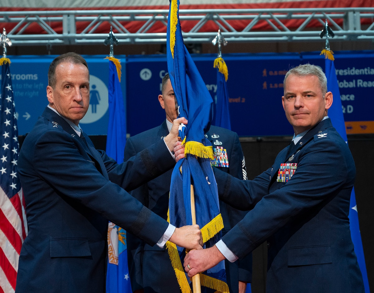 Lt. Gen. Shaun Q. Morris, Air Force Life Cycle Management Center commander, passes the 88th Air Base Wing guidon to Col. Christopher Meeker during a change of command ceremony July 7, 2022, inside the National Museum of the U.S. Air Force at Wright-Patterson Air Force Base, Ohio. The wing is responsible for three primary missions: operating the installation; training and deploying expeditionary Airmen in support of joint operations; and defending the base and its people. (U.S. Air Force photo by R.J. Oriez)