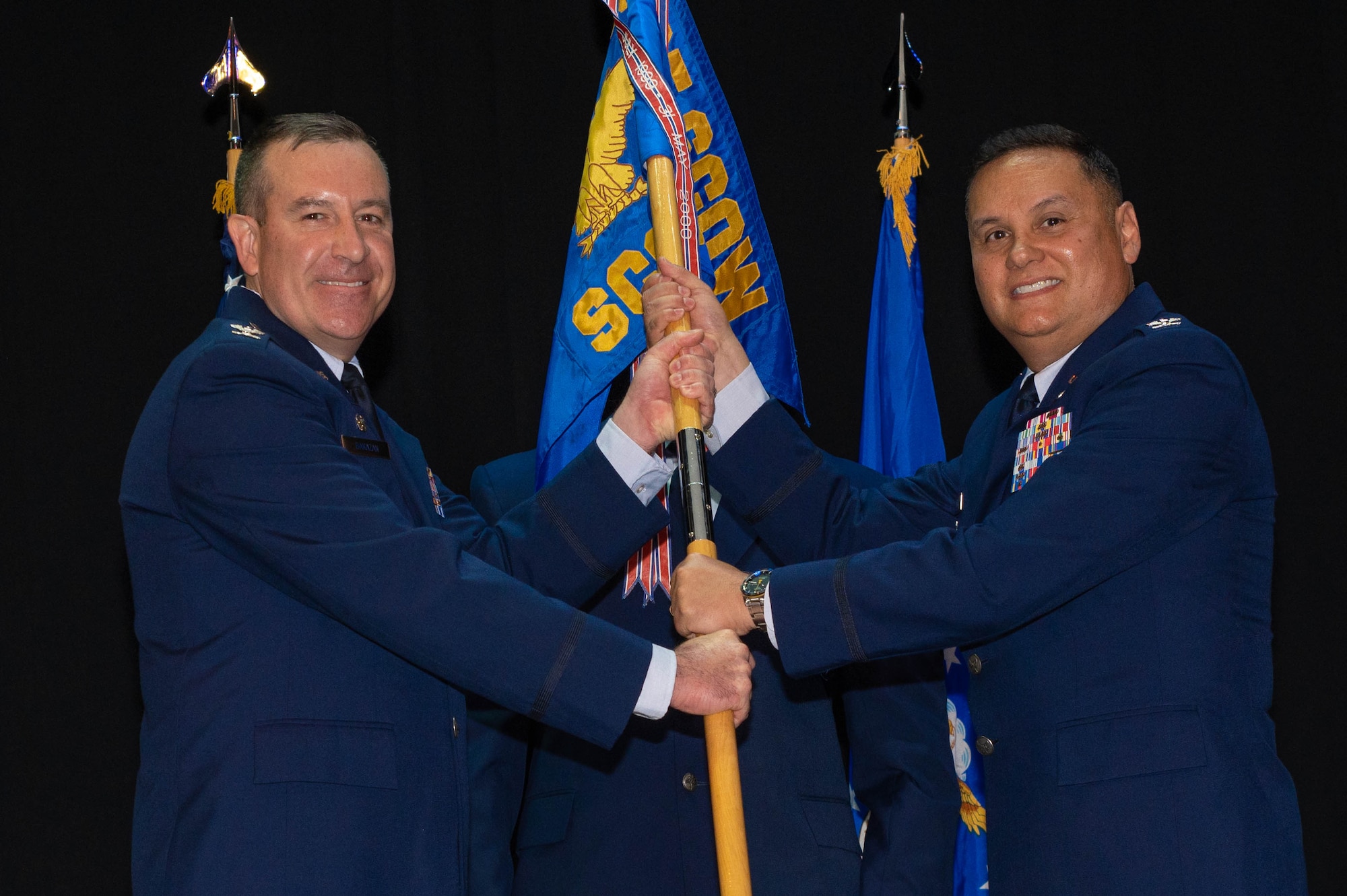 Two airmen holding flag.