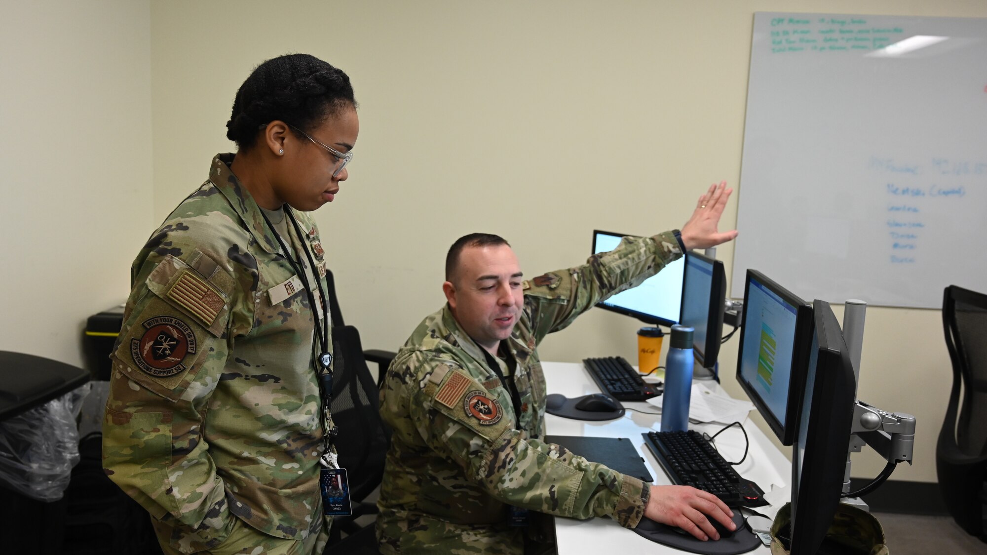 U.S. Air Force 1st Lt. Alexis Eyo (left), cyber officer assigned to the 275th Operations Support Squadron, and U.S. Air Force Maj. Charles Gruver, 275th Operations Support Squadron commander, talk about strategies before the start of Cyber Blitz 22-3 at Warfield Air National Guard Base, Middle River, Maryland on March 23, 2022.