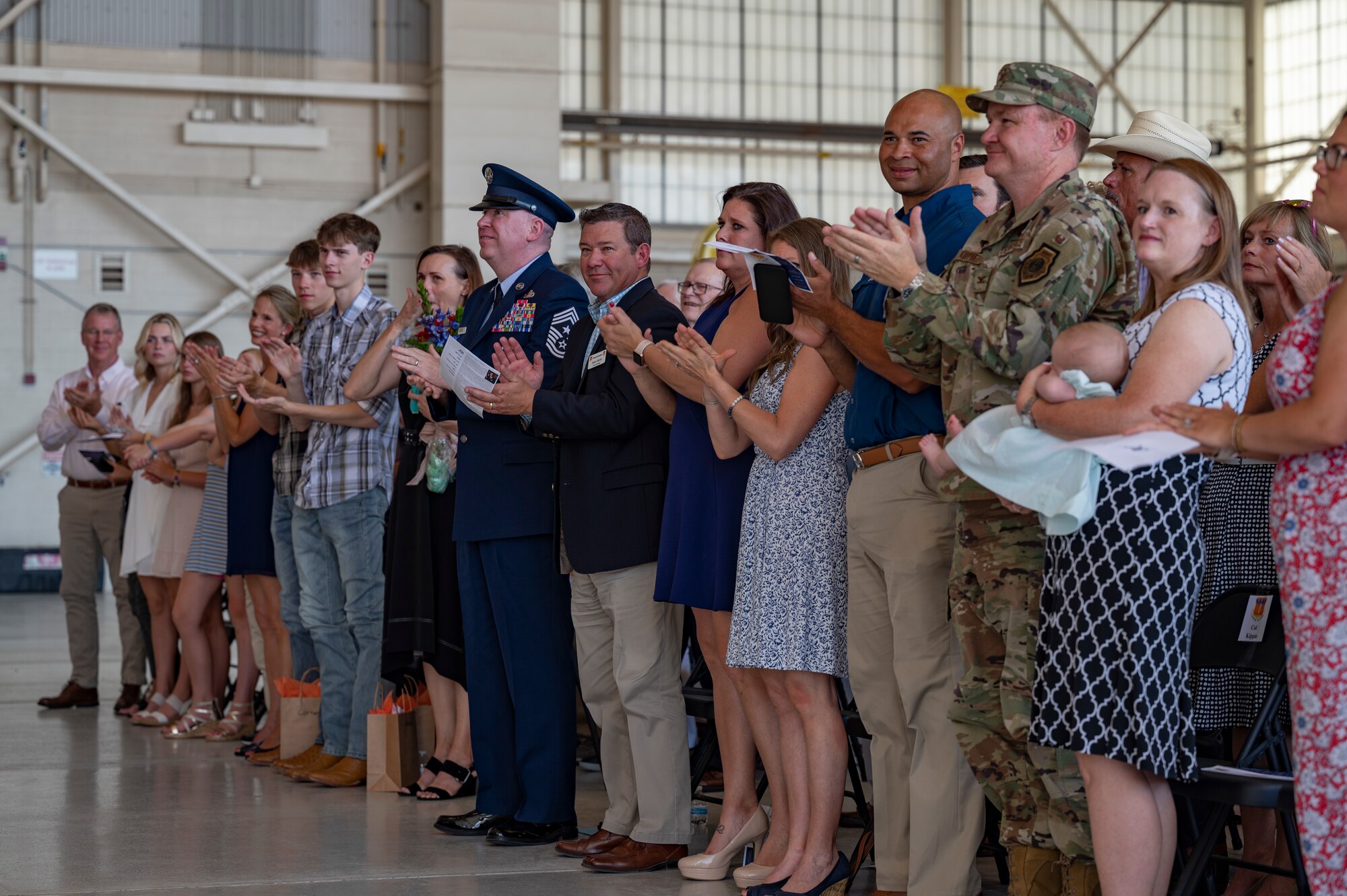 Audience members applaud during the 317th Change of Command ceremony at Dyess Air Force Base, Texas, July 7, 2022. The 317th Airlift Wing commander is responsible for organizing, training, and equipping 1,200 combat-ready personnel who operate, maintain, and sustain 28 C-130J aircraft. (U.S. Air Force photo by Senior Airman Josiah Brown)