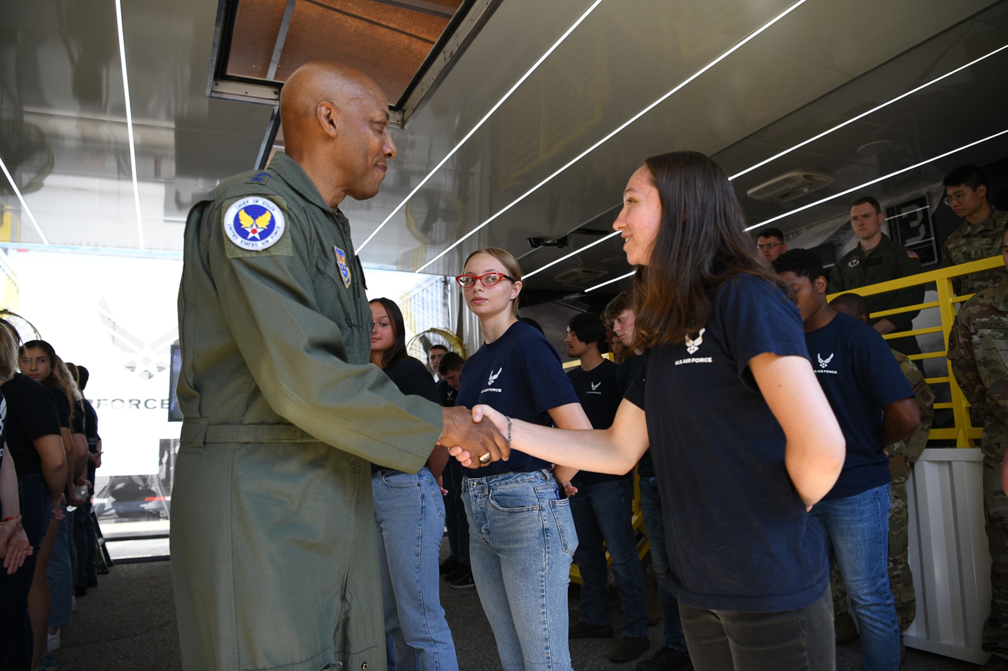 Air Force Chief of Staff Gen. CQ Brown, Jr. shakes hands with Caitlyn Ruttner, 17, from Mishicot, Wisconsin July 3, 2022 at Road America, near Elkhart Lake, Wisconsin, inside an Air Force national recruiting asset called “The Hangar.”