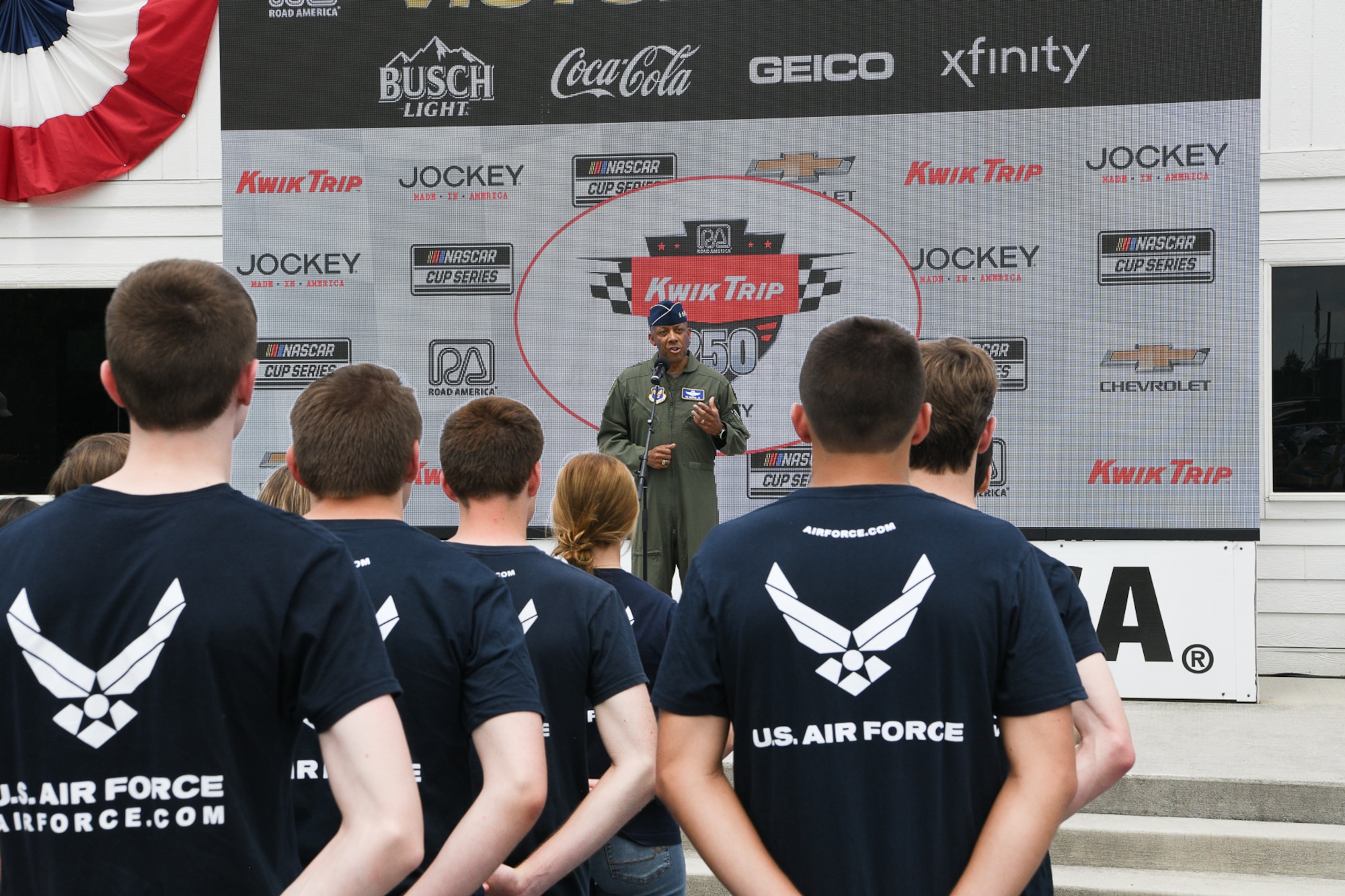 Air Force Chief of Staff Gen. CQ Brown, Jr., addresses a televised and in-person audience including 23 future Airmen who stood in a formation for their Oath of Enlistment ceremony on Victory Lane inside the Road America race course near Elkhart Lake, Wisconsin, July 3, 2022.