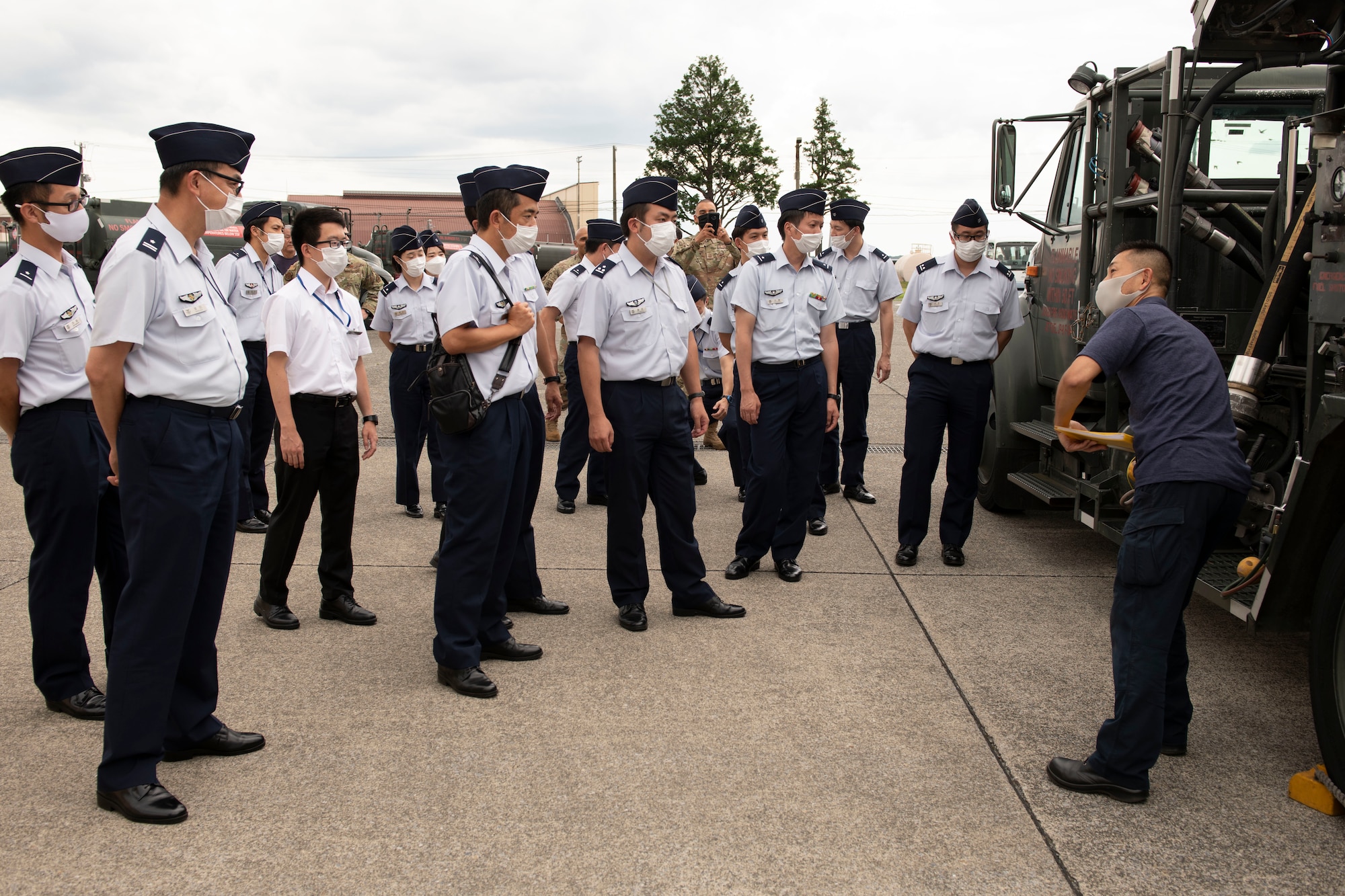 A fuel truck worker shows a group of Japanese officer cadets his truck
