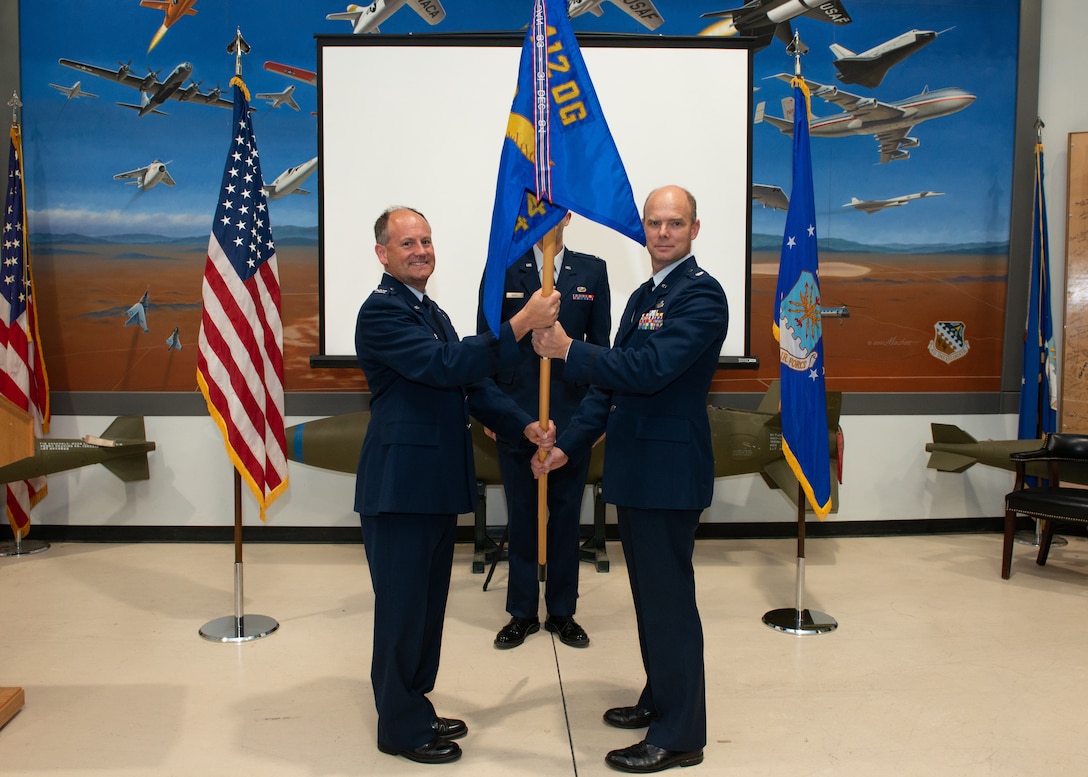 Col. Jay Orson, 412th Electronic Warfare Group Commander, hands over the newly-reactivated 445th Test Squadron’s guidon to its new commander, Lt. Col. James Petersen, during a reactivation and assumption of command ceremony on Edwards Air Force Base, California, June 29. (Air Force photo by Madeline Guadarrama)