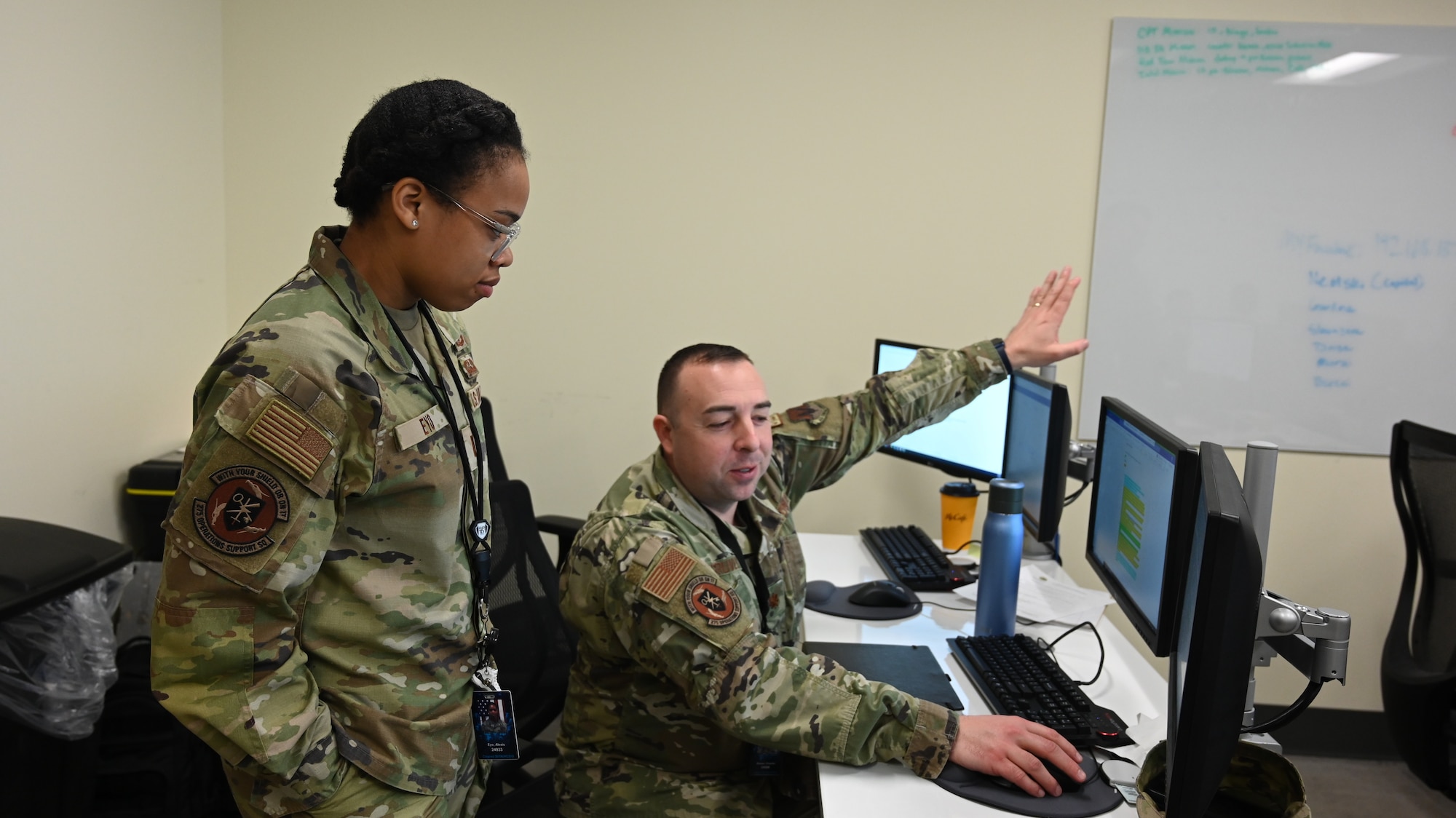 U.S. Air Force 1st Lt. Alexis Eyo (left), cyber officer assigned to the 275th Operations Support Squadron, and U.S. Air Force Maj. Charles Gruver, 275th Operations Support Squadron commander, talk about strategies before the start of Cyber Blitz 22-3 at Warfield Air National Guard Base, Middle River, Maryland on March 23, 2022.