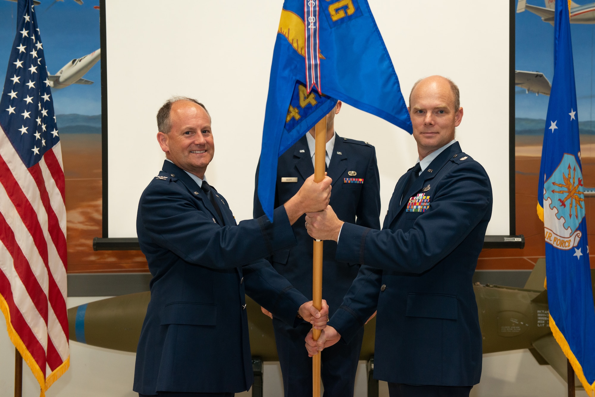 Col. Jay Orson, 412th Electronic Warfare Group Commander, hands over the newly-reactivated 445th Test Squadron’s guidon to its new commander, Lt. Col. James Petersen, during a reactivation and assumption of command ceremony on Edwards Air Force Base, California, June 29. (Air Force photo by Madeline Guadarrama)