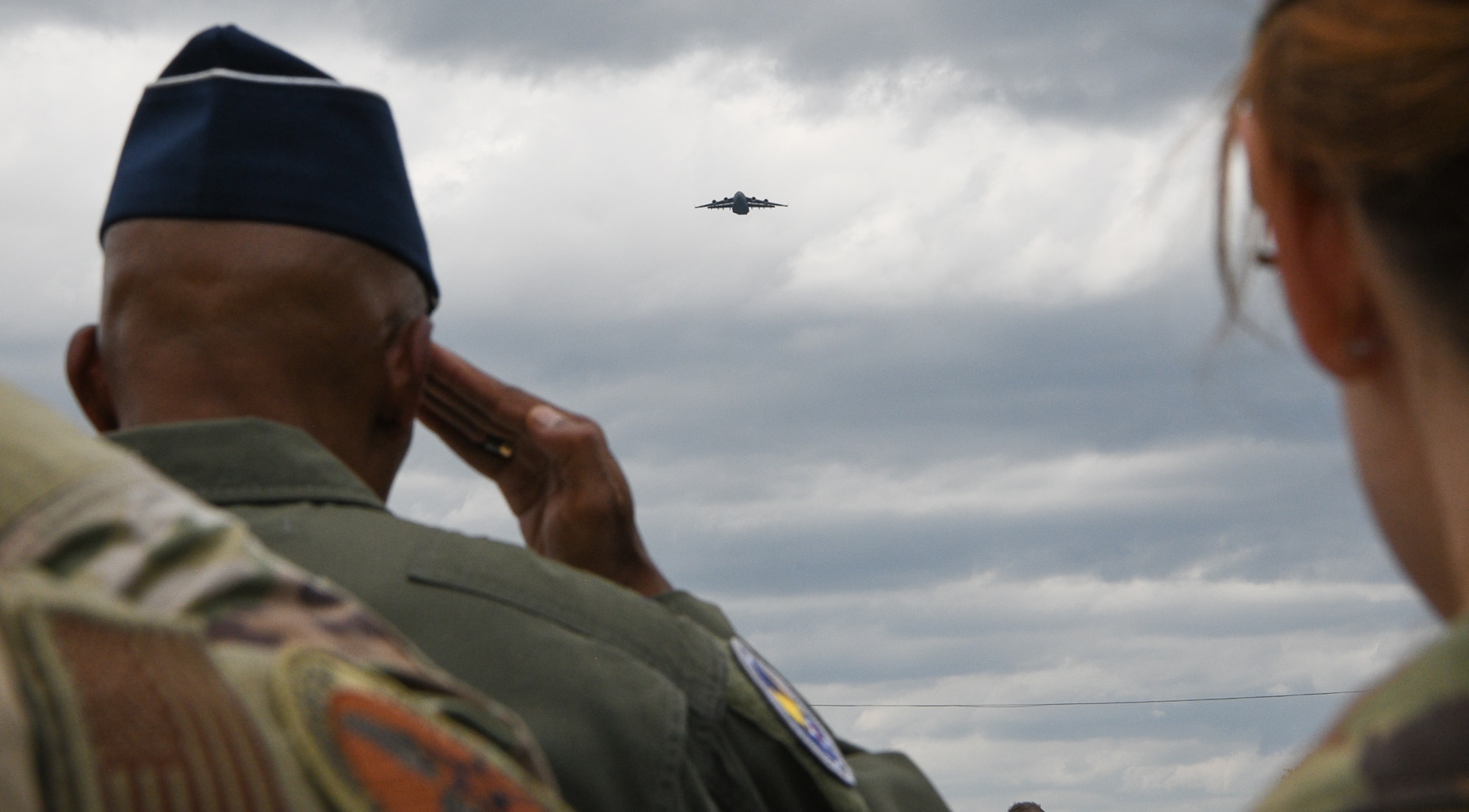 Air Force Chief of Staff Gen. CQ Brown, Jr., renders a salute during the playing of the National Anthem and opening ceremonies for the Kwik Trip 250 NASCAR Cup Series race at Road America near Elkhart Lake, Wisconsin, July 3, 2022 while a C-17 Globemaster III performs a flyover.