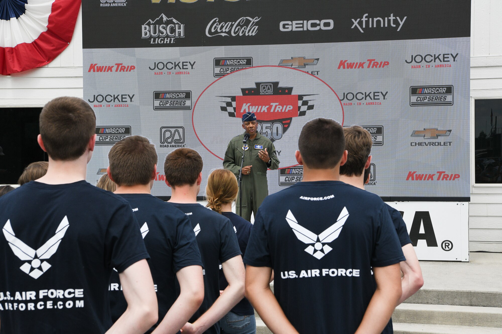 Air Force Chief of Staff Gen. CQ Brown, Jr., addresses a televised and in-person audience including 23 future Airmen who stood in a formation for their Oath of Enlistment ceremony on Victory Lane inside the Road America race course near Elkhart Lake, Wisconsin, July 3, 2022.