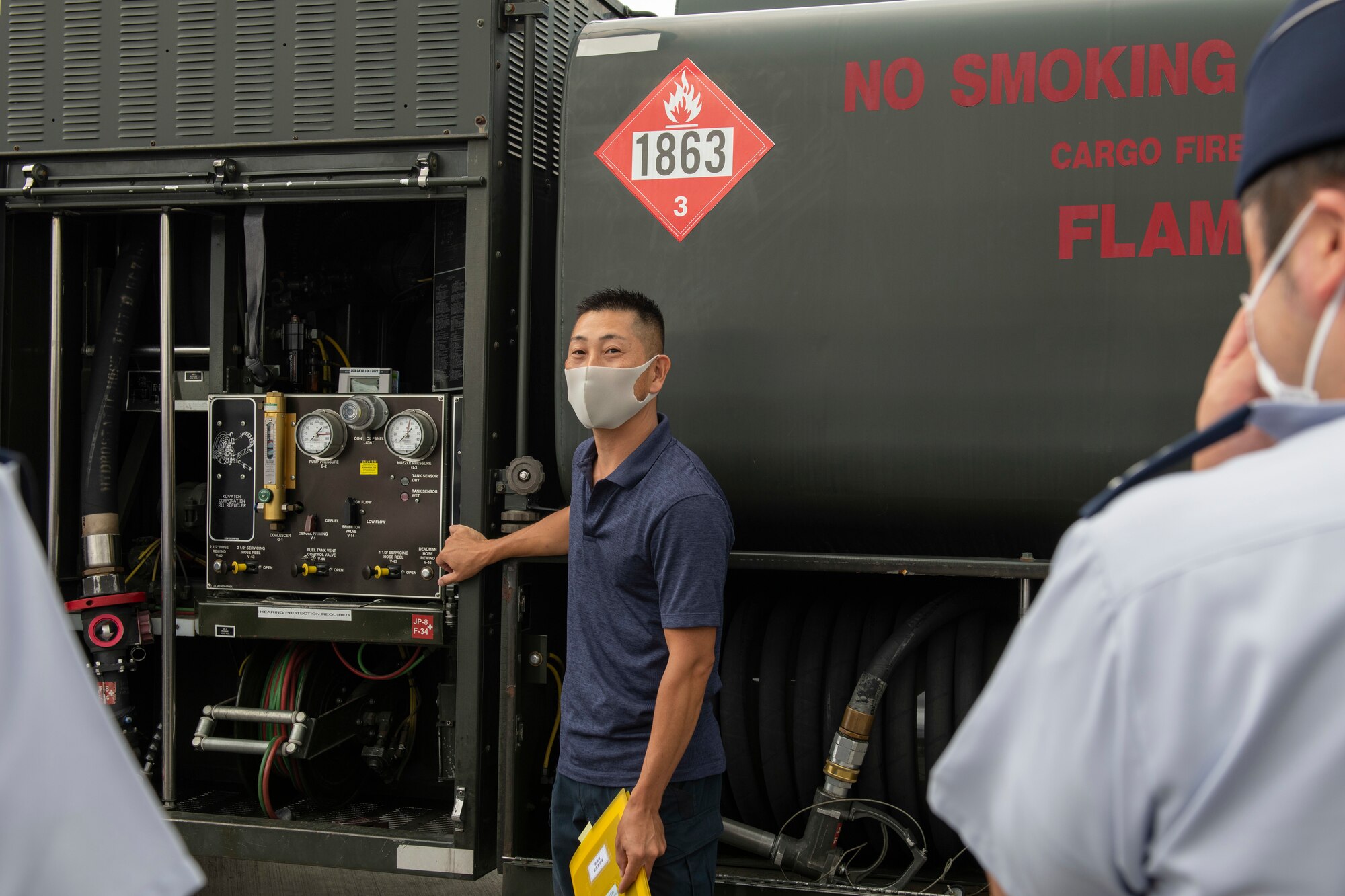 A fuel truck worker standing next to his truck