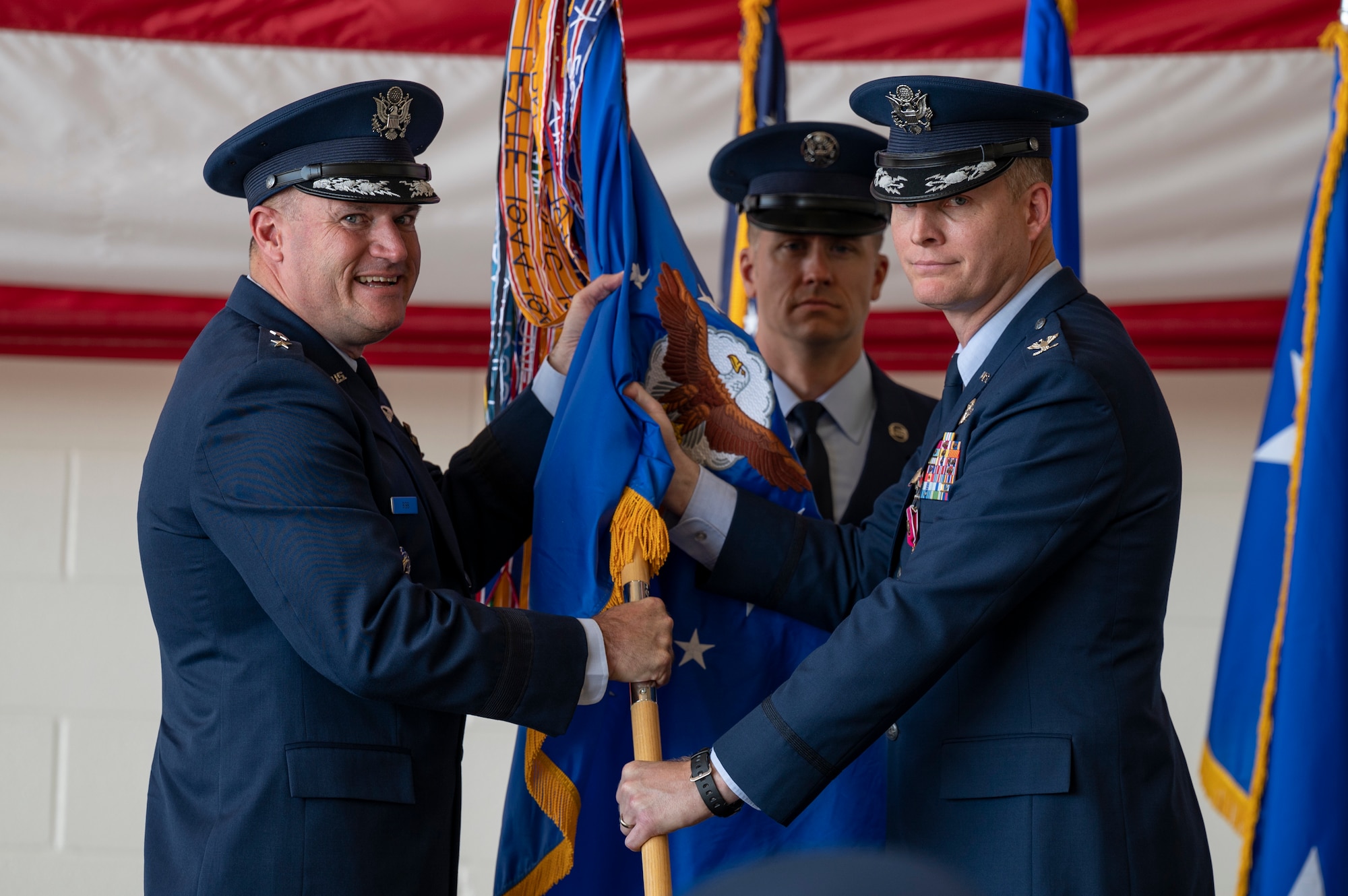 Maj. Gen. Kenneth Bibb, 18th Air Force commander, accepts the guidon from Col. James Young, outbound 317th Airlift Wing commander, at Dyess Air Force Base, Texas, July 7, 2022. The guidon represents the 317th AW and is presented to the incoming commander during the change of command ceremony. (U.S. Air Force photo by Senior Airman Josiah Brown)