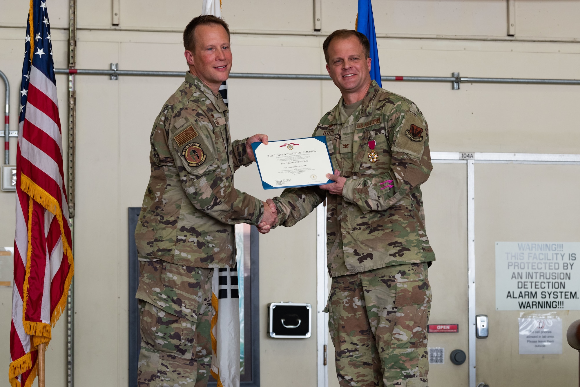 Col. Nathaniel Rusin, left, 480th Intelligence, Surveillance and Reconnaissance Wing commander, presents Col. Garry Floyd, 694th ISR Group outgoing commander, a Legion of Merit medal during a change of command at Osan Air Base, Republic of Korea, 8 July, 2022.