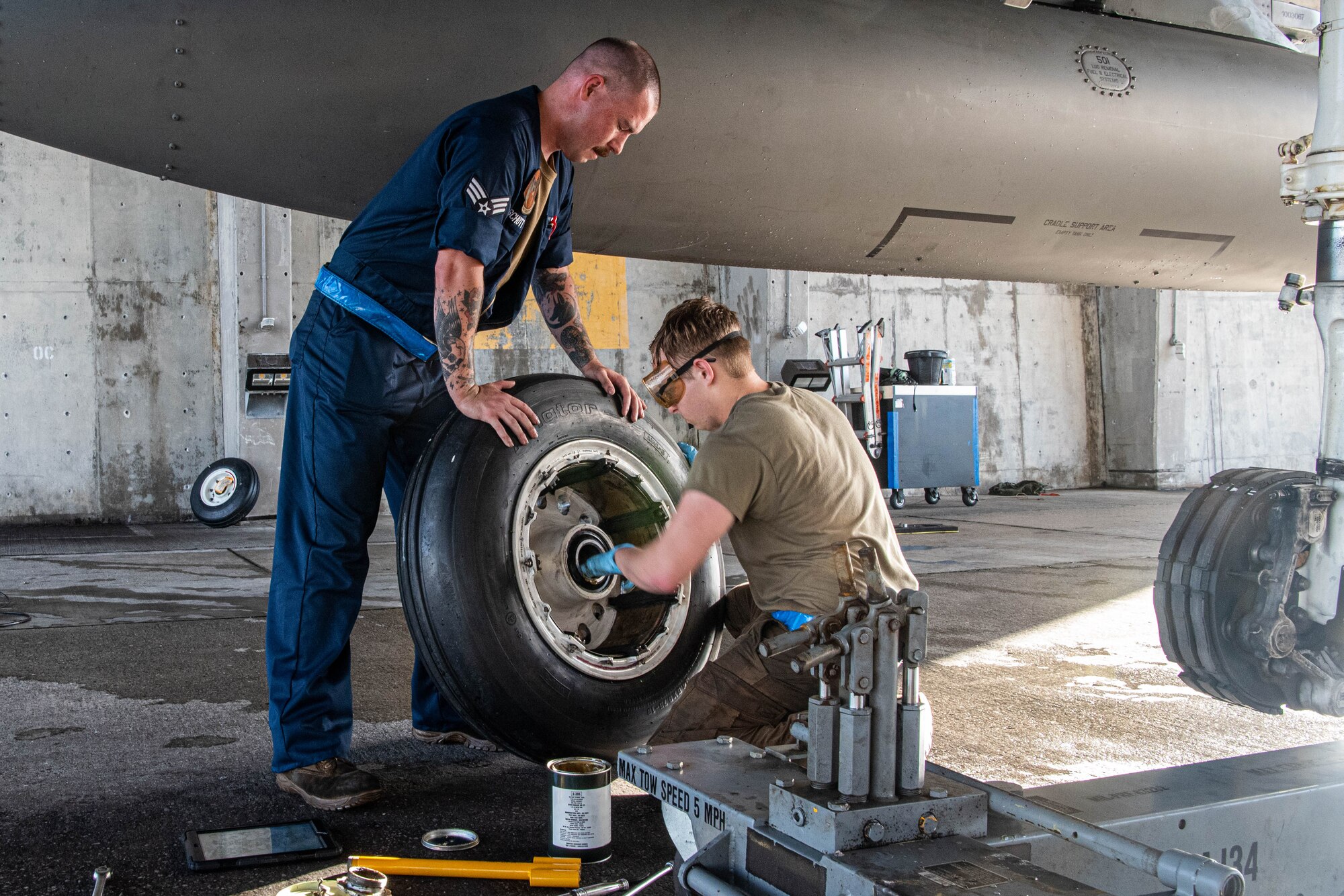 Airmen from the 44th AMU lubricate a main landing gear wheel of an F-15C Eagle prior to mounting.