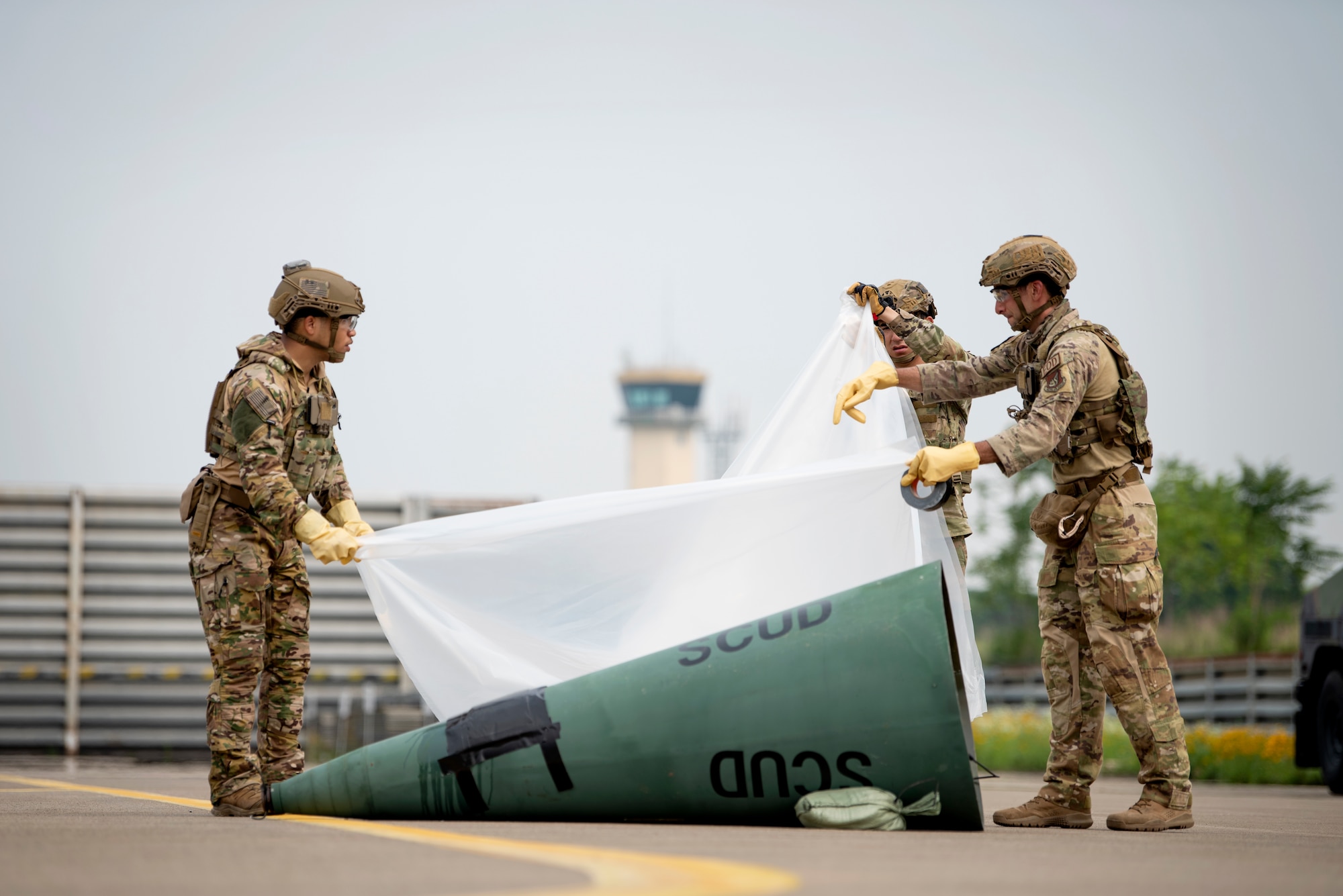U.S. Air Force Senior Airmen Joshua Young and Omar Navarro, along with Staff Sgt. Michael Augustus, 35th Civil Engineer Squadron, Explosive Ordnance Disposal technicians from Misawa Air Base, Japan, cover a mock chemical weapon during a bilateral training event at Suwon Air Base, Republic of Korea, July 6, 2022.