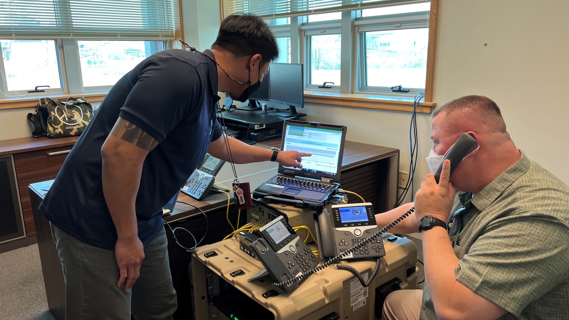 Two DLA employees setup satellite indoor monitoring terminal.