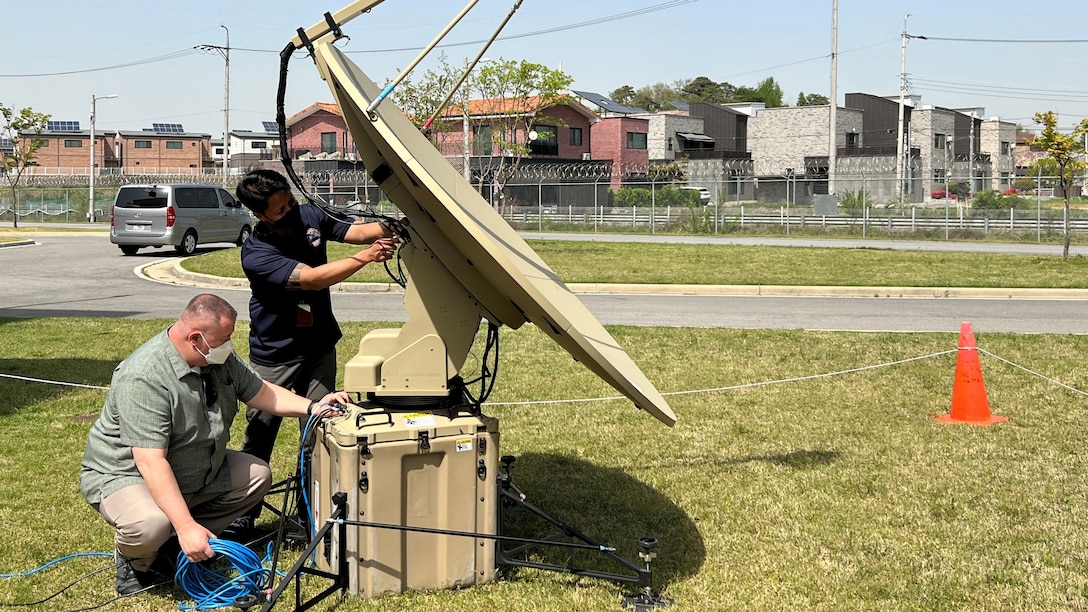 DLA employees adjust positioning of a satellite dish.