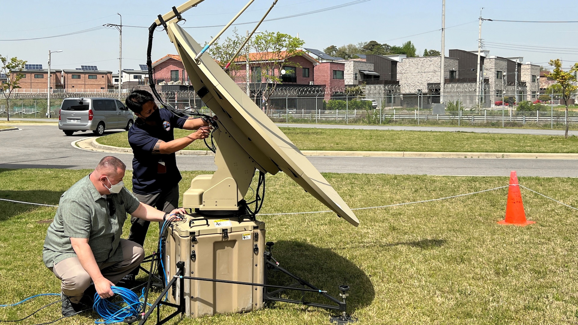 DLA employees adjust positioning of a satellite dish.