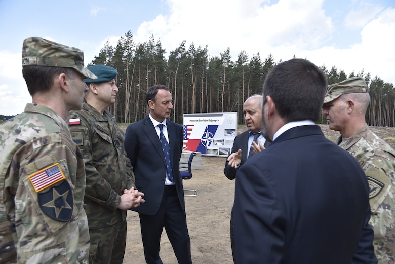 U.S. Army Corps of Engineers, Europe District Commander Col. Pat Dagon, Plenipotentiary to the Minister of Defense for the Enhanced Defense Cooperation Agreement Polish Brig. Gen. Dariusz Mendrala, NATO Investment Committee Chair Emanuele Meli, Europe District Chief of Program Management Branch Lalit Wadhwa, Europe District Chief of Programs and Project Management Justin Wetherwax and Poland Provided Infrastructure Program Manager U.S. Army Col. Eric McFadden discuss military construction efforts in Poland June 2, 2022 in Powidz ahead of the groundbreaking ceremony for the Munitions Storage Area being constructed there. The ceremony marked the beginning of the Poland Provided Infrastructure program, which provides a mechanism for sharing the costs for U.S. forces in Poland. Infrastructure projects are funded by Poland and are designed and constructed to meet U.S. requirements for use by U.S. forces operating in Poland. For its part, the U.S. will continue to bear the costs of training, equipping, deploying and employment of U.S. forces in the country. (U.S. Army photo by Chris Gardner)