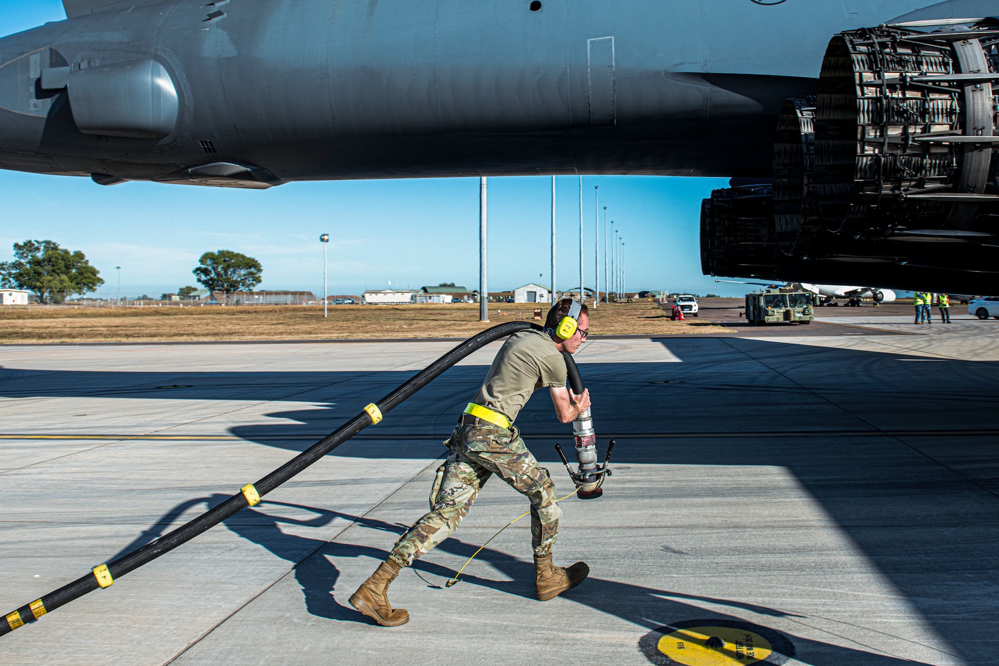 Airman 1st Class Justin Snyder, 28th Logistics Readiness Squadron fuels distribution operator, assigned to Ellsworth Air Force Base, South Dakota, pulls a refueling hose to a U.S. Air Force B-1B Lancer attached to the 34th Bomb Squadron during a hot pit refueling at RAAF Base Darwin, NT, Australia, for a Bomber Task Force mission June 22, 2022.