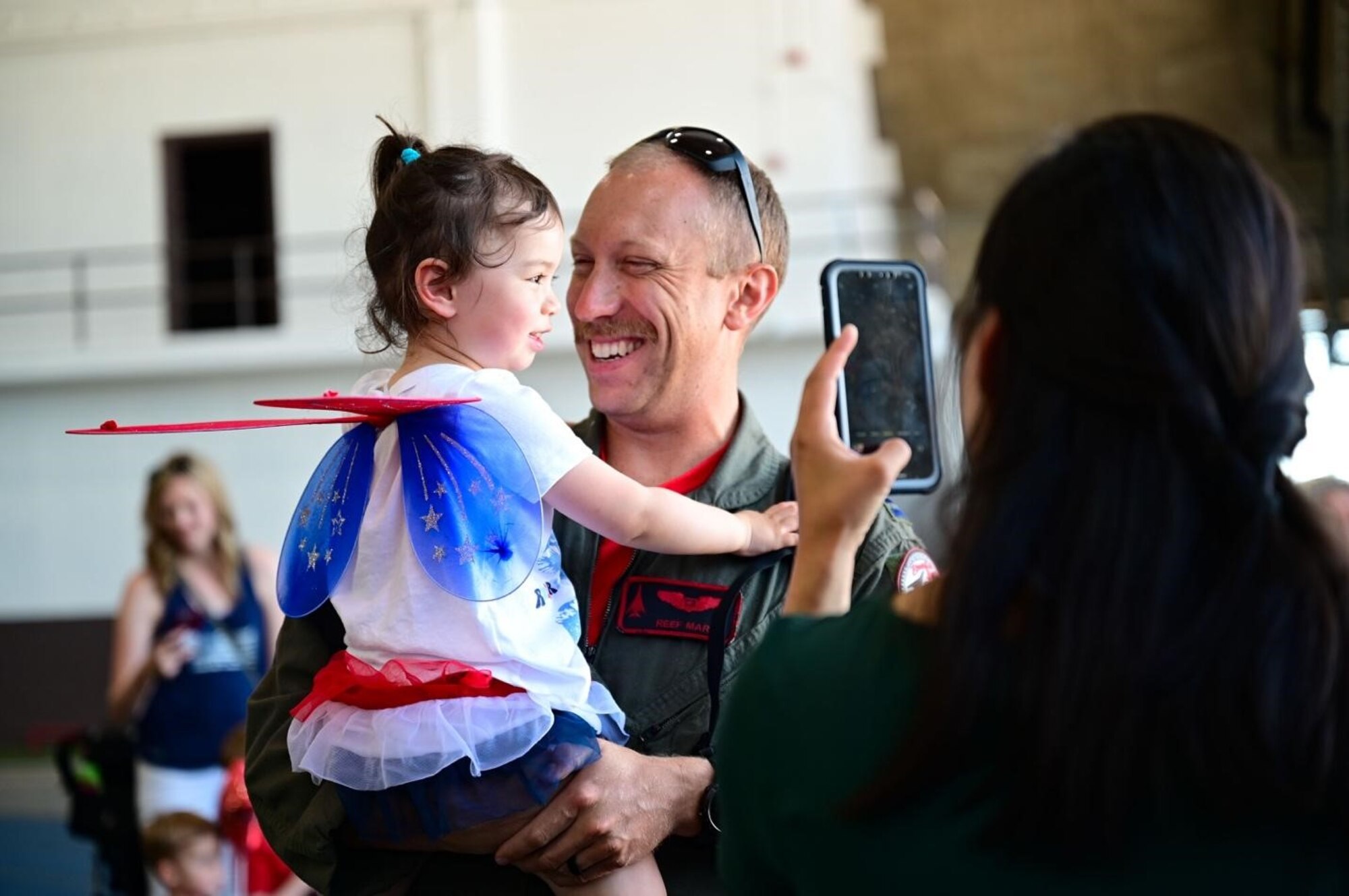 A weapons system operator, assigned to 34th Bomb Squadron, reunites with his family at Ellsworth Air Force Base, South Dakota, after returning from a Bomber Task Force Mission, July 4.