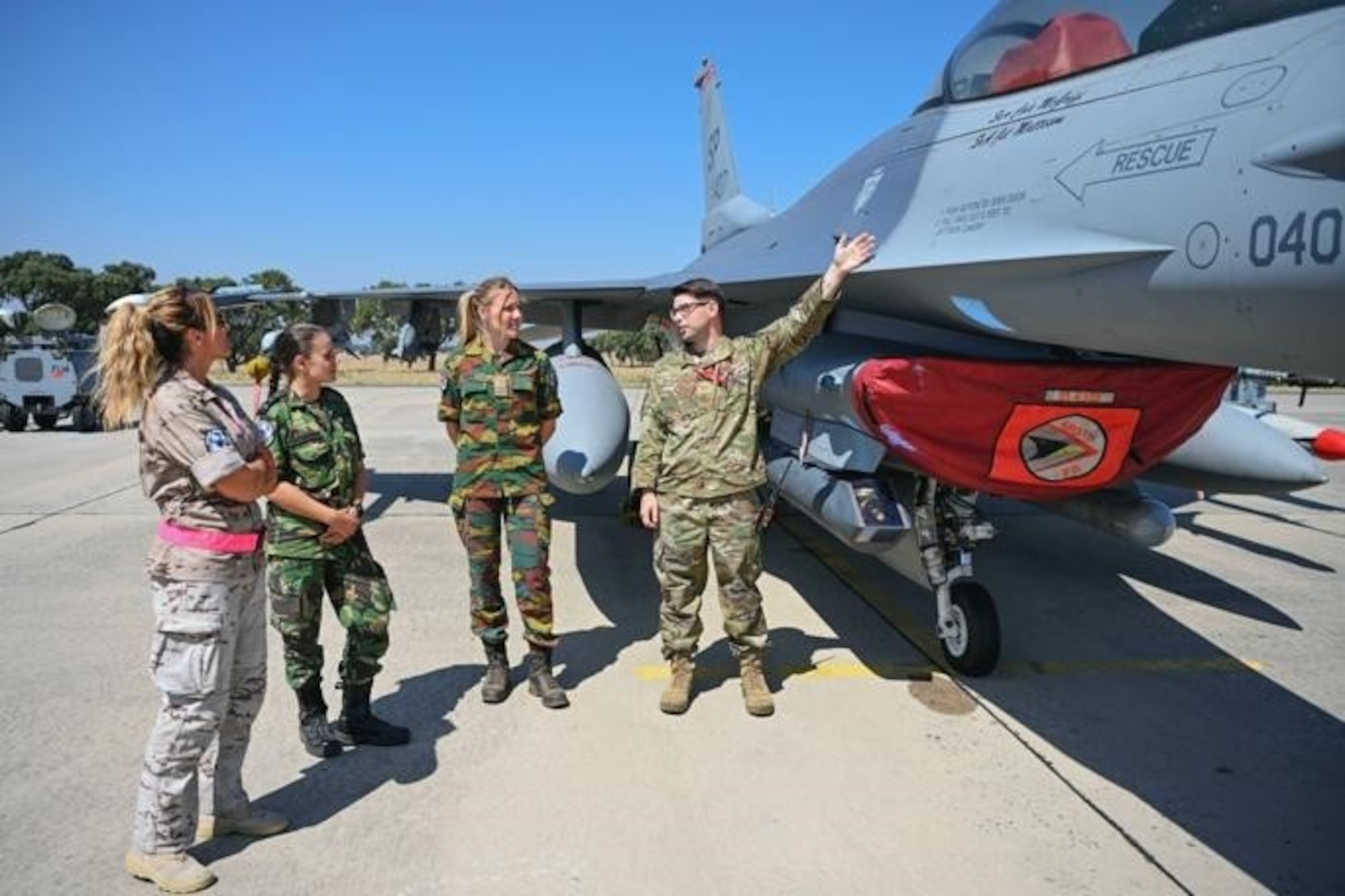 U.S. Air Force Tech. Sgt. Donovan Guffey, 480th Fighter Squadron specialist expediter (right), stationed at Spangdahlem Air Base, Germany, discusses some of the functions of a U.S. Air Force F-16 Fighting Falcon aircraft to NATO partners from Spain, Belgium and Portugal at Exercise Real Thaw 22 on Beja Air Base, Portugal, July 6, 2022. Training alongside Allies and neighbors in Europe helps the United States maintain the relationships and trust essential for ensuring regional security. (U.S. Air Force photo by Tech. Sgt. Warren D. Spearman Jr.)