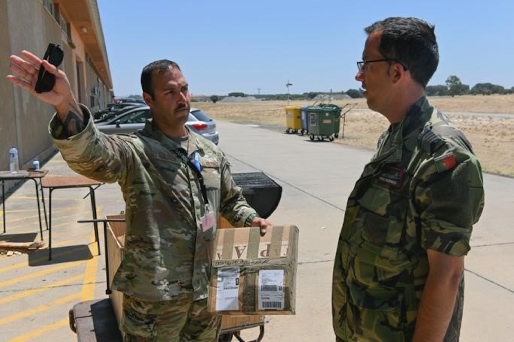 U.S. Air Force Master Sgt. Mark Majack, 52nd  Logistics Readiness Squadron cargo movement section chief (left), stationed at Spangdahlem Air Base, Germany, discusses logistical support with Portuguese air force 1st Sgt. Figueiredo at Exercise Real Thaw 22 on Beja Air Base, Portugal, July 6, 2022. Participation in joint exercises and training enhances NATO’s interoperability and readiness. (U.S. Air Force photo by Tech. Sgt. Warren D. Spearman Jr.)