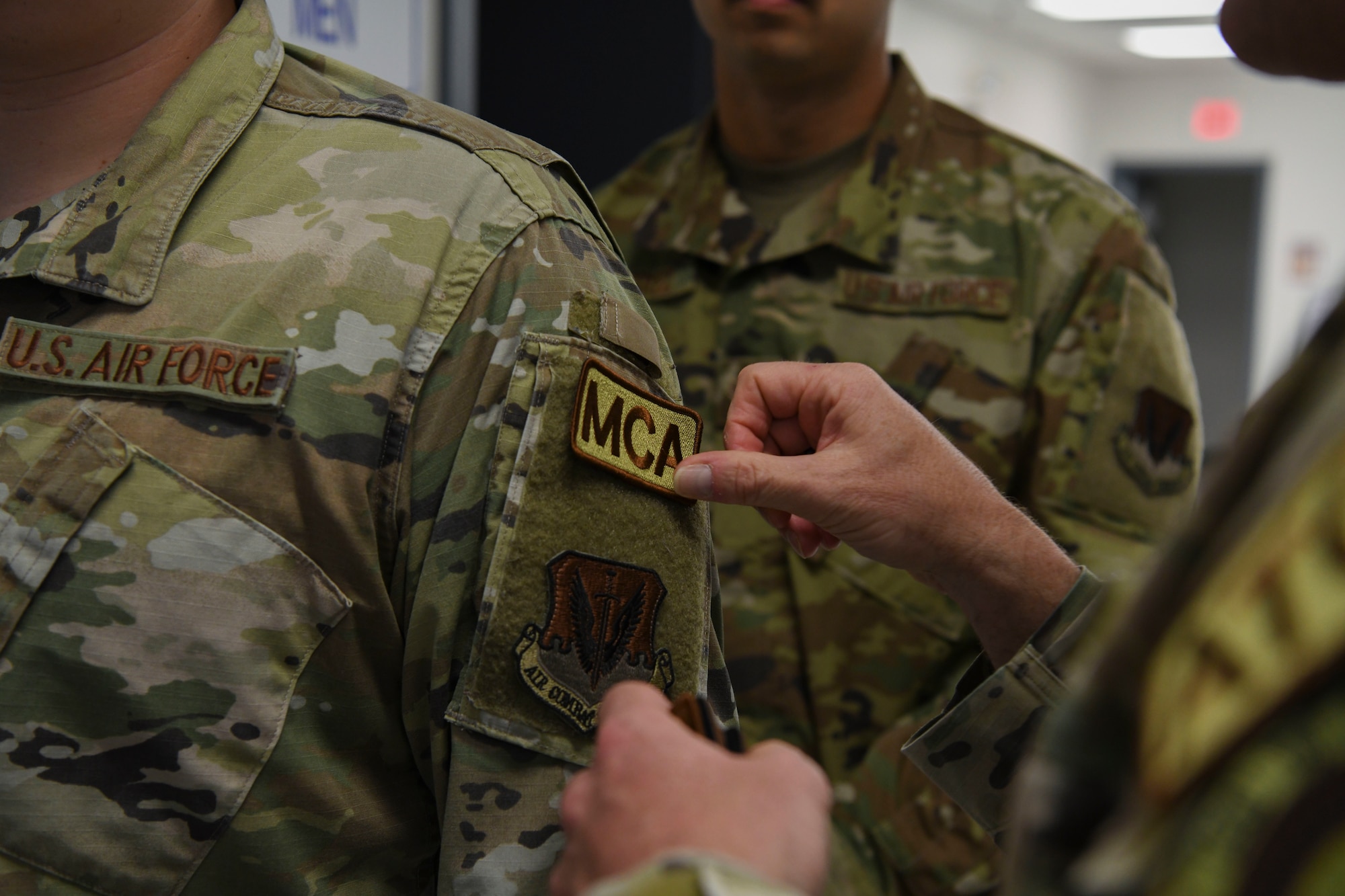 An airman has a patch placed on his arm.