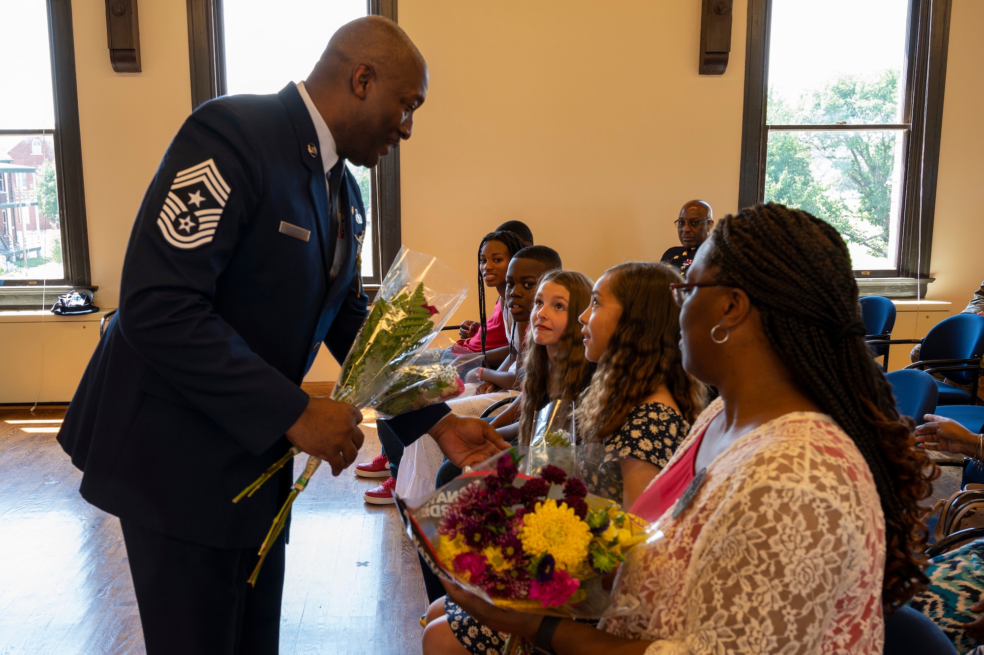 Chief Master Sgt. LeRoy E. McCardell Jr., 131st Bomb Wing command chief master sergeant, gives his daughters flowers during his retirement ceremony, June 25, 2022, at Jefferson Barracks Air National Guard Base, St. Louis, Missouri. McCardell served for 34 years. (U.S. Air National Guard photo by Senior Airman Whitney Erhart)