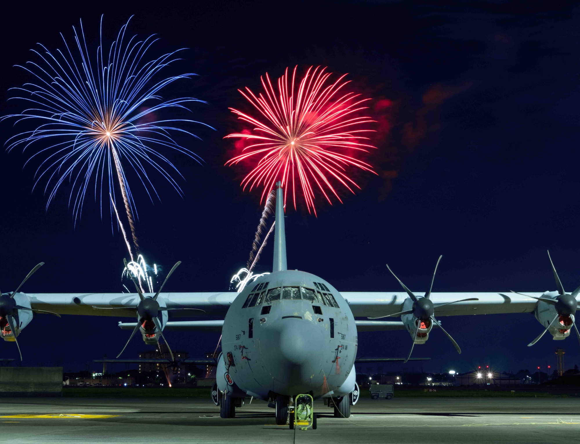 Fireworks explode behind a C-130J Super Hercules