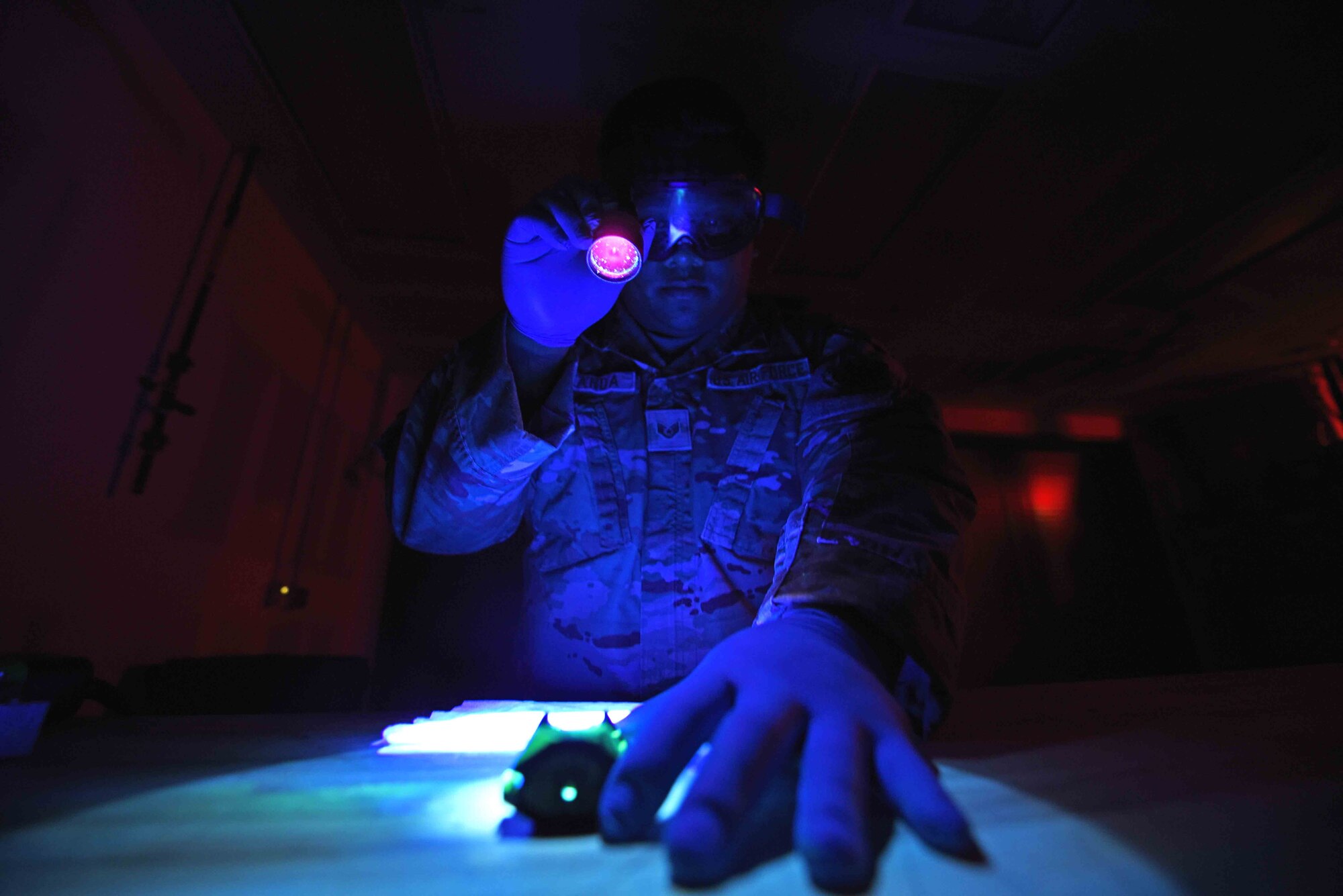 Staff Sgt. Alvinjason Aranda, 325th Maintenance Squadron nondestructive inspection craftsman, checks a piece of a firearm