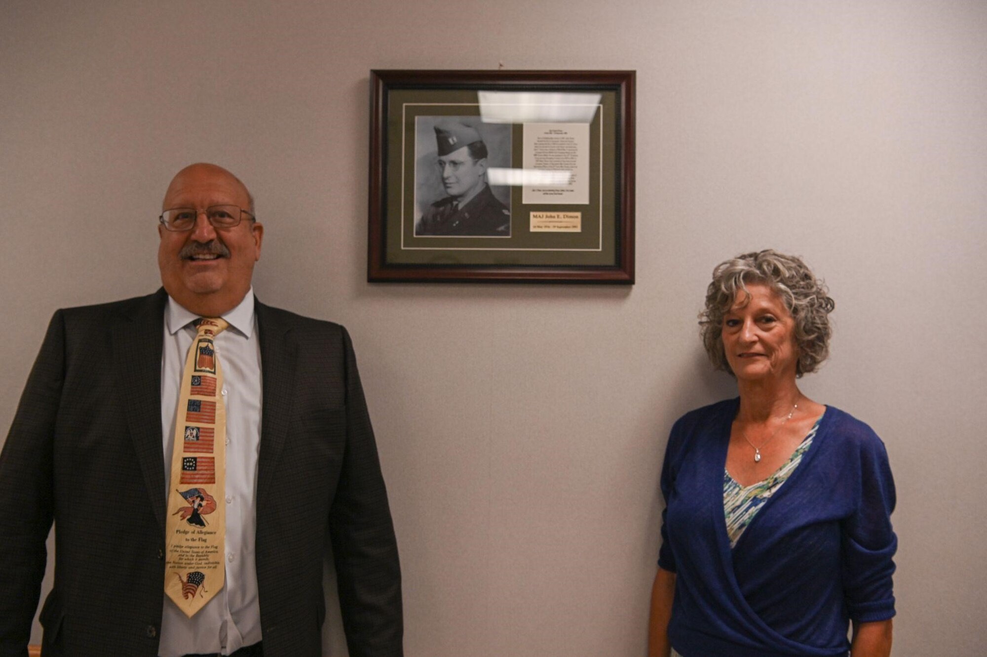 Man and woman stand in front of plaque
