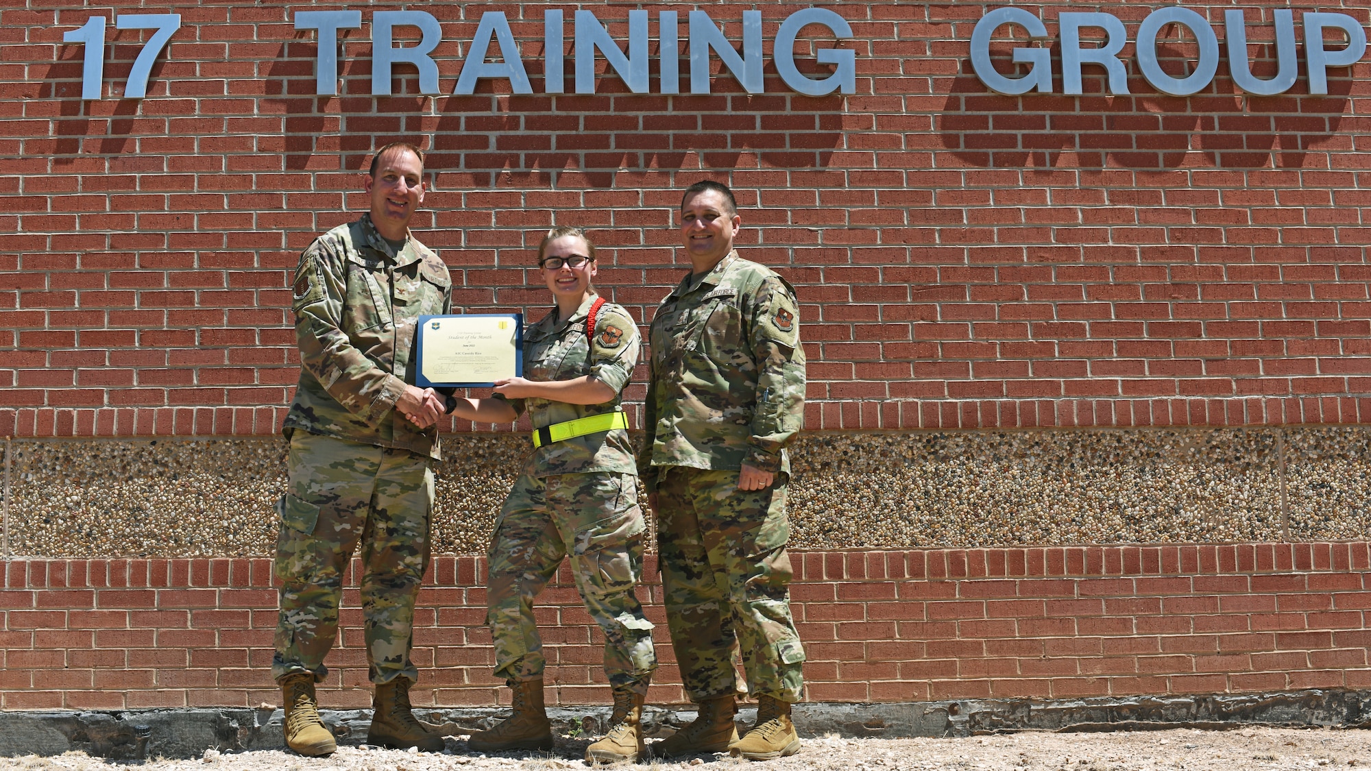 U.S. Air Force Col. Jason Kulchar, 17th Training Group commander, and Chief Master Sgt. Cody Bringham, 315th Training Squadron senior enlisted leader, presents the 316th Training Squadron Student of the Month award to Airman 1st Class Cassidy Rice, 316th TRS student, Goodfellow Air Force Base, Texas, July 8, 2022. Rice worked hard for her award and has shown her dedication to her squadron and the training she received at Goodfellow. (U.S. Air Force photo by Airman 1st Class Zachary Heimbuch)