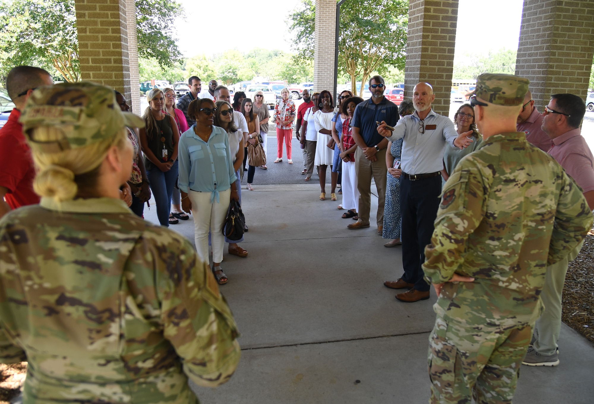 Members of the Biloxi and Jackson County School Districts administration meet with 81st Training Wing leadership outside of the Bay Breeze Event Center at Keesler Air Force Base, Mississippi, July 7, 2022. The visit included tours of the student dorms and the weather and air traffic control training courses. (U.S. Air Force photo by Kemberly Groue)