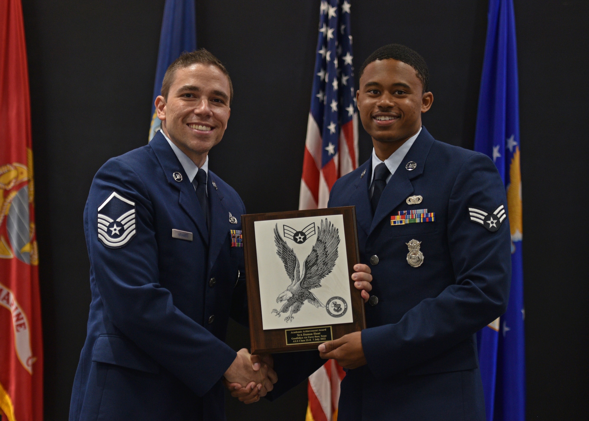 U.S. Air Force Master Sgt. Donald Kramer, 312th Training Squadron Special Instruments Training instructor supervisor, presents Senior Airman Damon Hunt, 17th Security Forces Squadron military working dog handler, the Academic Achievement award during the Airman Leadership School graduation at the Powell Event Center, Goodfellow Air Force Base, Texas, July 7, 2022. The Academic Achievement award recognizes an Airman who demonstrated superior leadership as identified by their peers and the ALS staff. (U.S. Air Force photo by Senior Airman Ashley Thrash)