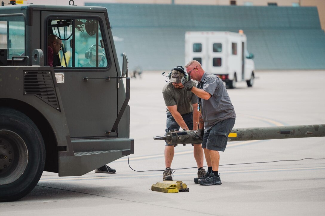 Civilian maintainers from the 28th Aircraft Maintenance Squadron attach a tow bar to a B-1B Lancer returning from a Bomber Task Force mission at Ellsworth Air Force Base, S.D., June 29, 2022.