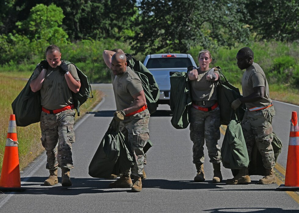 Airmen carry duffle bags.