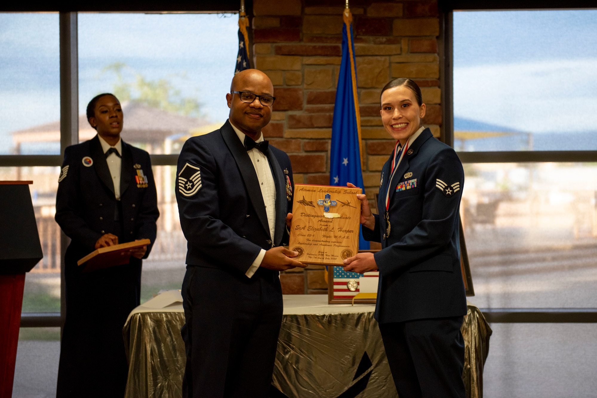 Senior Airman Elizabeth L. Harper, Airman Leadership School graduate, accepts the Distinguished Graduate Award from Master Sgt. Troy Campbell, Holloman Top III representative, during the graduation of ALS class 22-6, July 7, 2022, on Holloman Air Force Base, New Mexico.