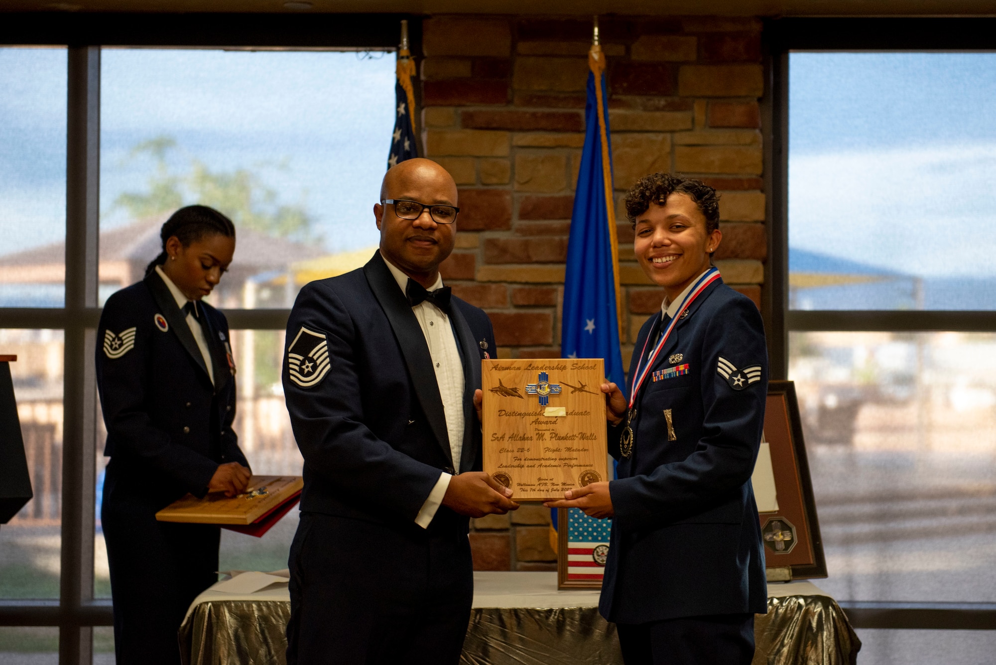 Senior Airman Allahna M. Plunkett-Walls, Airman Leadership School graduate, accepts the Distinguished Graduate Award from Master Sgt. Troy Campbell, Holloman Top III representative during the graduation of ALS class 22-6, July 7, 2022, on Holloman Air Force Base, New Mexico.