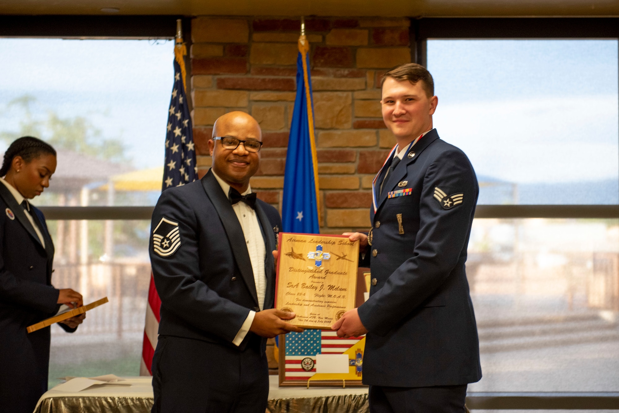 Senior Airman Bailey J. Melum, Airman Leadership School graduate, accepts the Distinguished Graduate Award from Master Sgt. Troy Campbell, Holloman Top III representative during the graduation of ALS class 22-6, July 7, 2022, on Holloman Air Force Base, New Mexico.