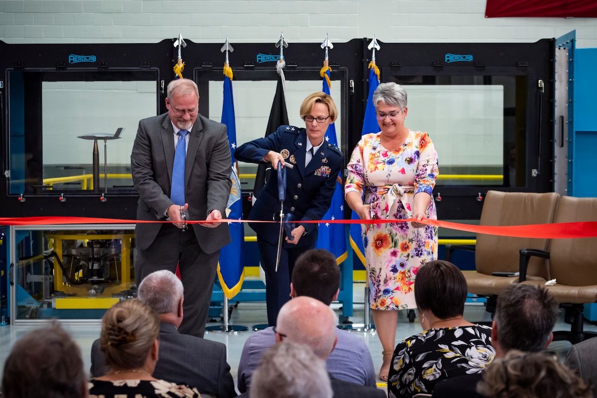 Air Force Research Laboratory Aerospace Systems Directorate Director Dr. Michael Gregg, far left, AFRL Commander Maj. Gen. Heather Pringle and Davilyn Parker, wife of AFRL Aerospace Engineer Dr. Greg Parker, cut a ribbon during the Parker Subsonic Research Facility, or SuRF, dedication ceremony at Wright-Patterson Air Force Base, Ohio, July 7, 2022. The facility is named after Dr. Greg Parker, a beloved member of AFRL's Aerospace Systems Directorate, who died after a long battle with cancer. SuRF is a low-speed wind tunnel used to evaluate prototype models including 3D-printed components that allows engineers to validate new aircraft designs. (U.S. Air Force photo / Rick Eldridge)