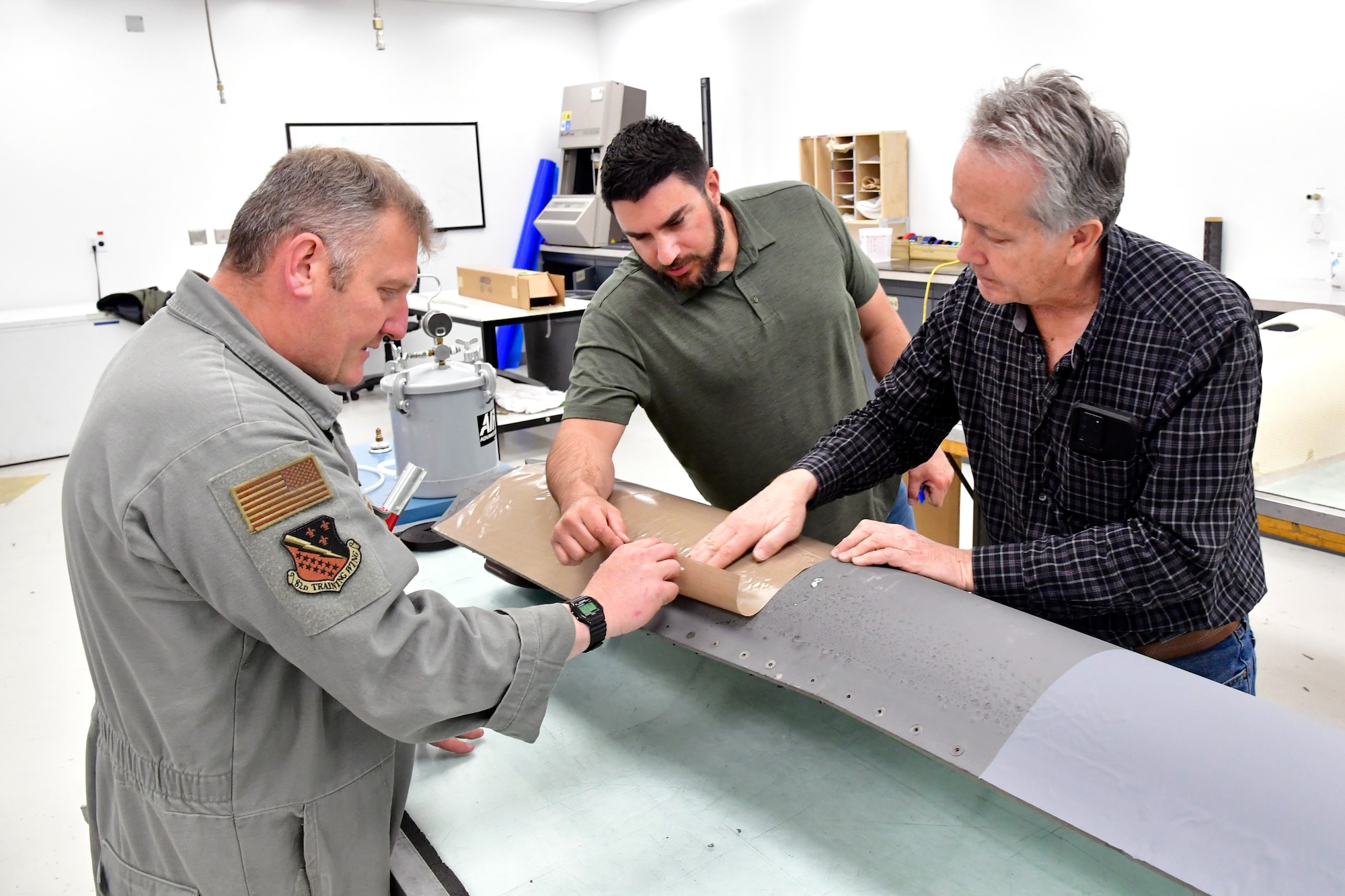 From left, Master Sgt. Andrew Wilkow, 372nd Training Squadron, Det. 3, works with Brian Saavedra and Edward Bartling, Air Force Life Cycle Management Center advanced composite office on surface coating options to be applied to F-35 parts being turned into a sectional training aids by the 372nd Training Squadron, Det. 3, for use during instruction of F-35 maintainers. (U.S. Air Force photo by Todd Cromar)