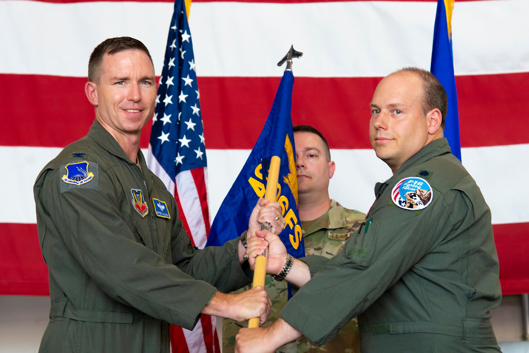 Col. John Galloway hands a guidon to Lt. Col. Daniel O'Neal, activating the 306th Fighter Squadron.