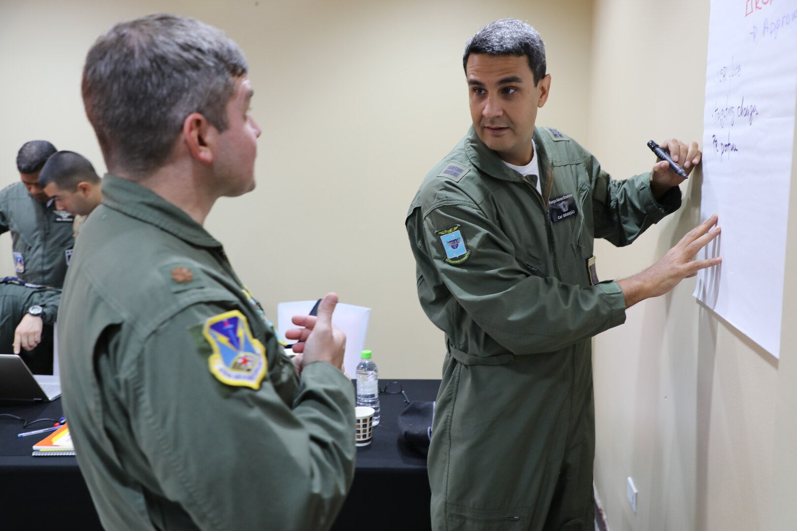Brazilian Air Force Col. Gabriel Brandao, discusses with U.S. Air Force Maj. Andrew Long during the Planning in Crisis (PIC) conference 22-30 June, 2022, in Panama City, Panama. During this conference air component planners from 10 Caribbean and Latin American countries coordinated air force operations for the upcoming PANAMAX 2022 exercise.