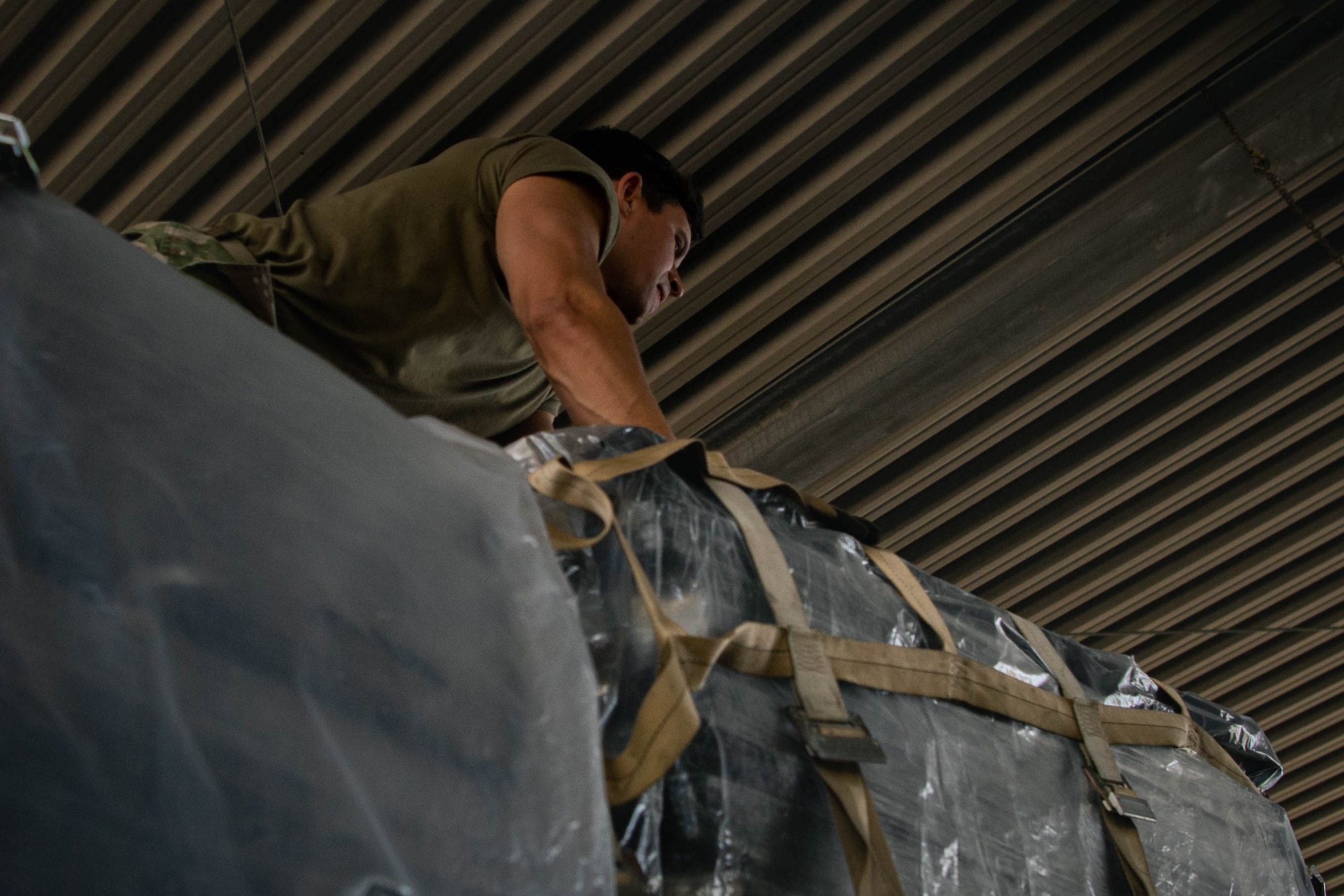 Airman  arranges straps on the top of a pallet