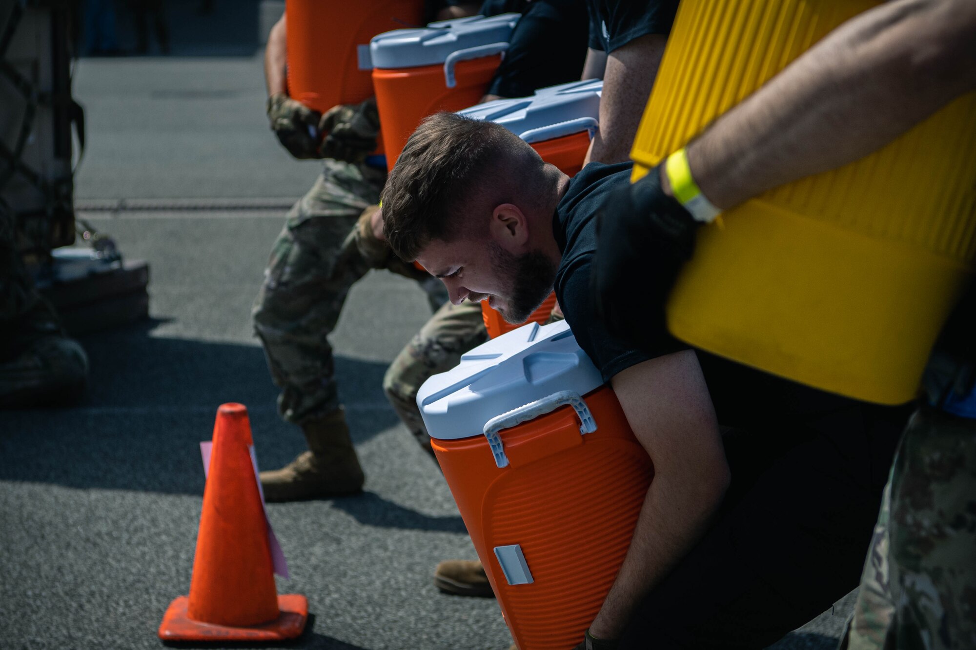 Members of  the 727th Air Mobility Squadron carry weighted coolers