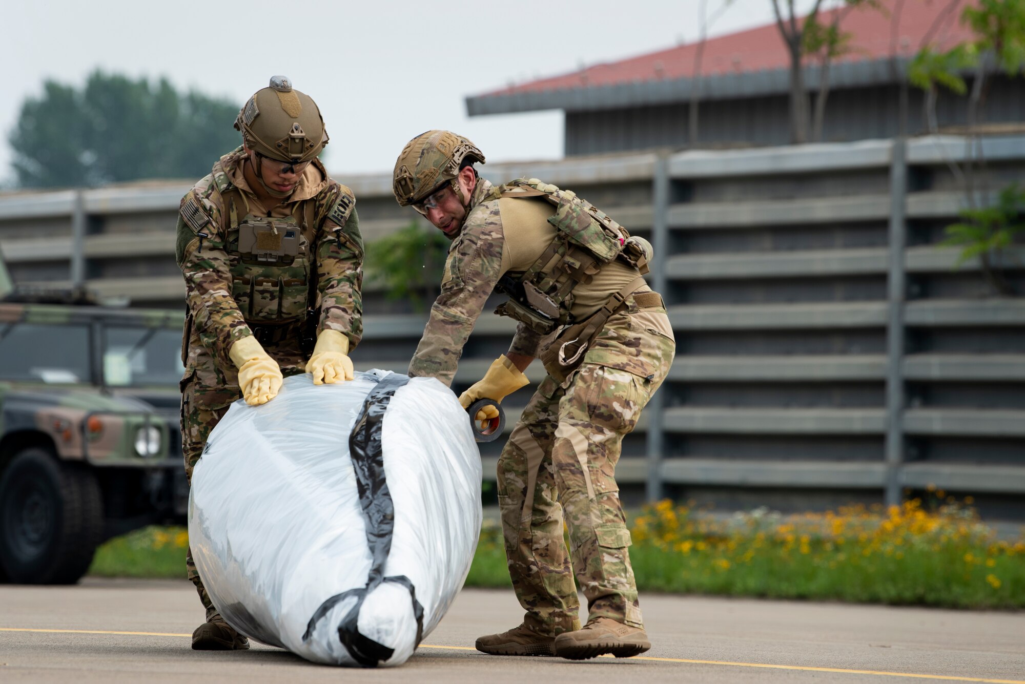 U.S. Air Force Senior Airman Joshua Young and Staff Sgt. Michael Augustus, 35th Civil Engineer Squadron, Explosive Ordnance Disposal (EOD) technicians from Misawa Air Base, Japan, practice covering a mock chemical weapon during a bilateral training event at Suwon Air Base, Republic of Korea, July 6, 2022.