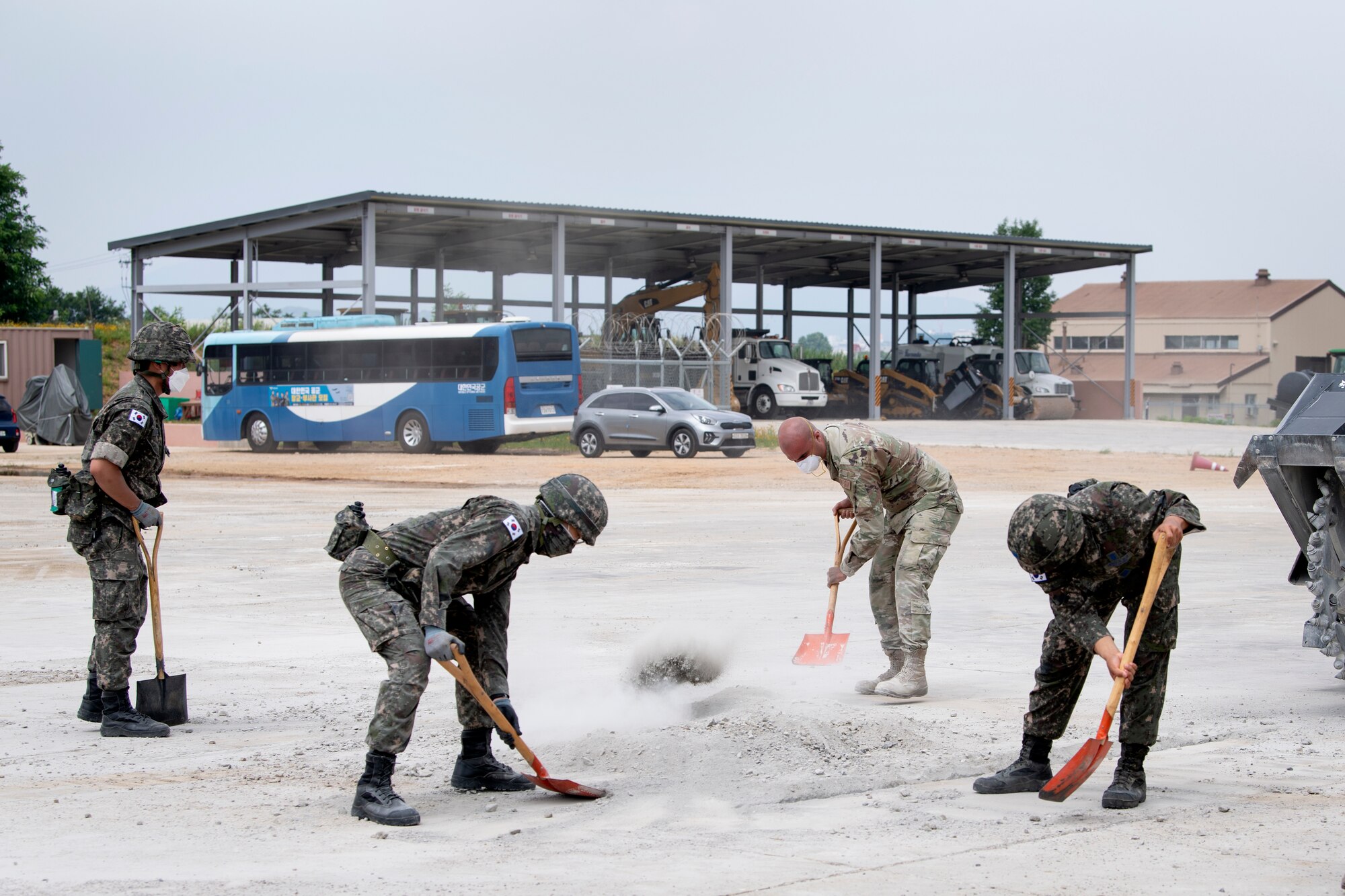 Senior Airman Ernesto Silio Cabrera, 35th Civil Engineer Squadron, water and fuels system maintenance technician from Misawa Air Base, Japan, and members of the Republic of Korea Air Force (ROKAF), shovel cement debris while conducting a runway repair training as part of a bilateral training scenario at Suwon Air Base, Republic of Korea, July 6, 2022