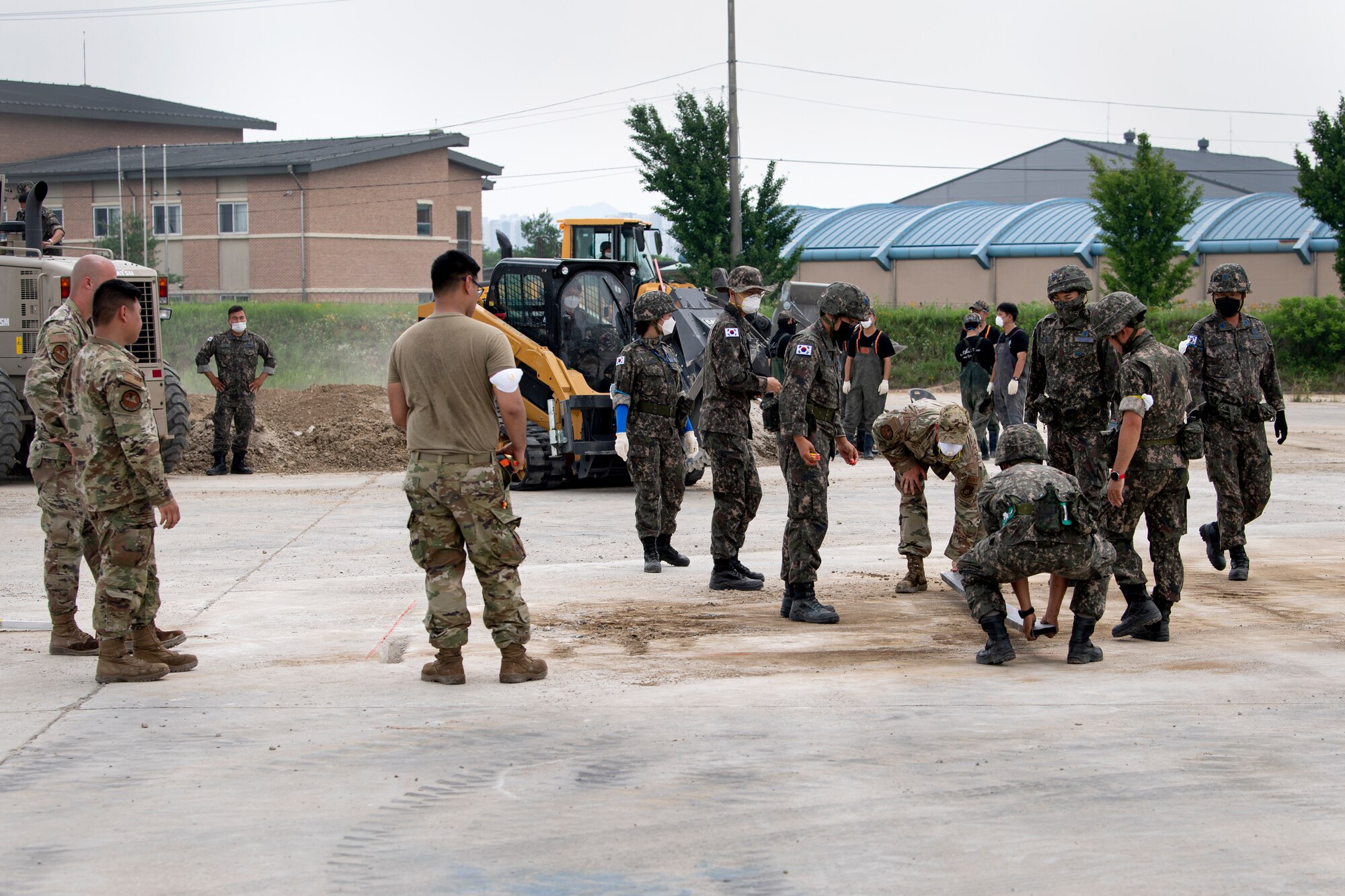 Members assigned to various sections of the 35th Civil Engineer Squadron from Misawa Air Base, Japan, and members of the Republic of Korea Air Force, mark an area of cement to be repaired during a bilateral training scenario at Suwon Air Base, Republic of Korea, July 6, 2022.