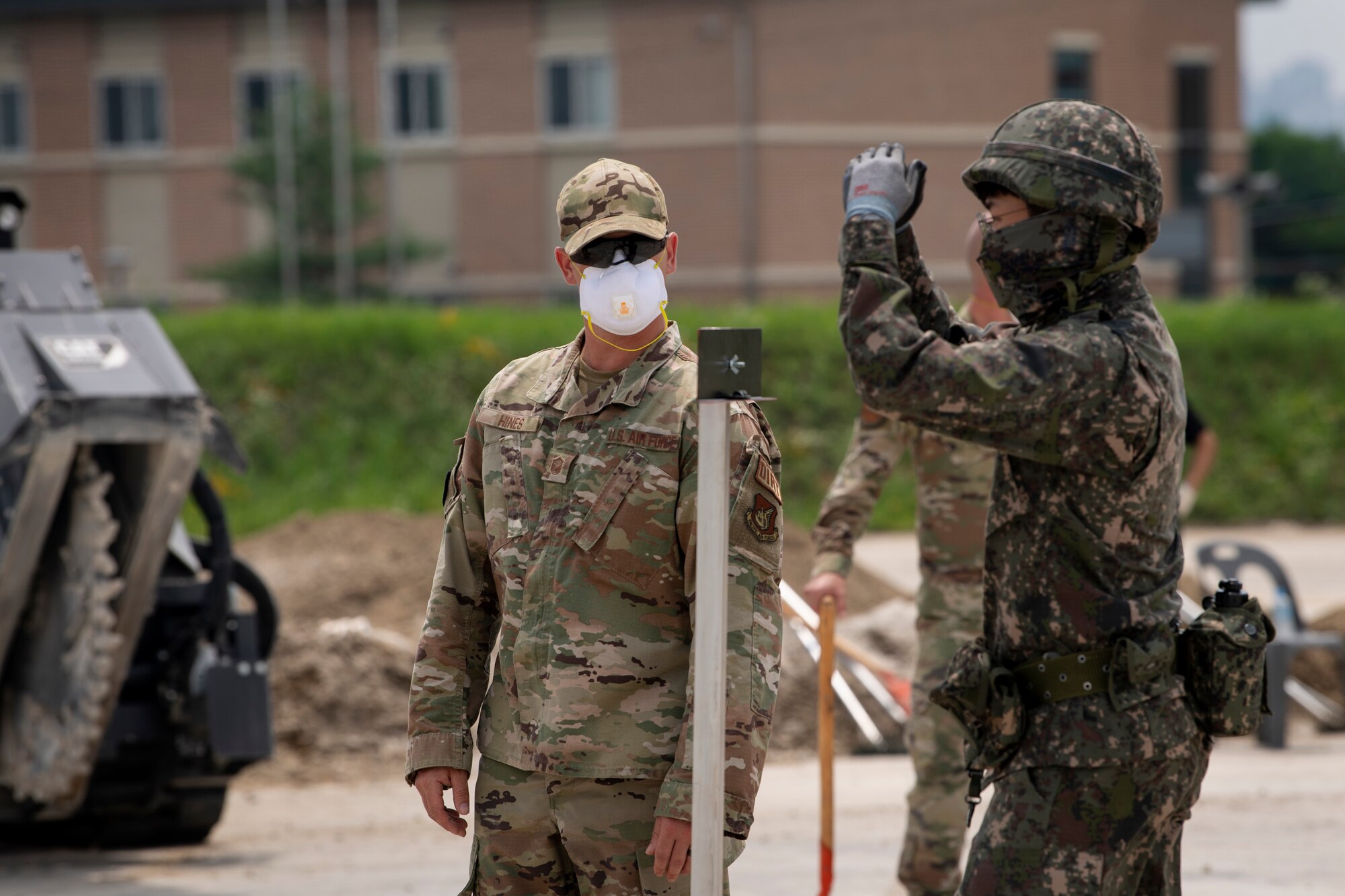 Master Sgt. Marcus Hines, 35th Civil Engineer Squadron, horizontal repair shop superintendent from Misawa Air Base, Japan, observes a member of the Republic of Korea Air Force giving hand signals during a runway repair training event as part of a bilateral training scenario at Suwon Air Base, Republic of Korea, July 6, 2022.