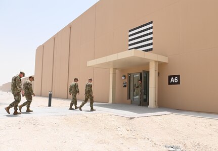 379th Air Expeditionary Wing leadership approaches a newly finished dorm during a tour of new facilities July 2, 2022 at Al Udeid Air Base, Qatar. The new dorms will look to increase both quality of life and safety for airmen at AUAB. (U.S. Air National Guard photo by Tech. Sgt. Michael J. Kelly)